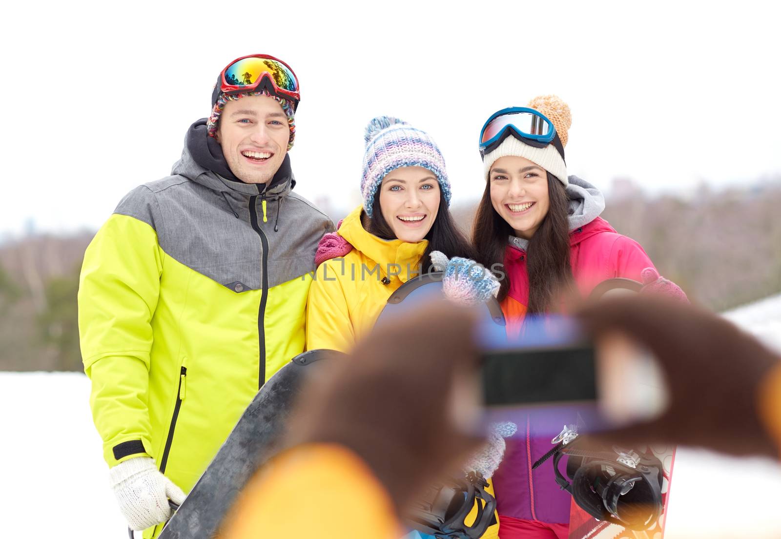 happy friends with snowboards and smartphone by dolgachov