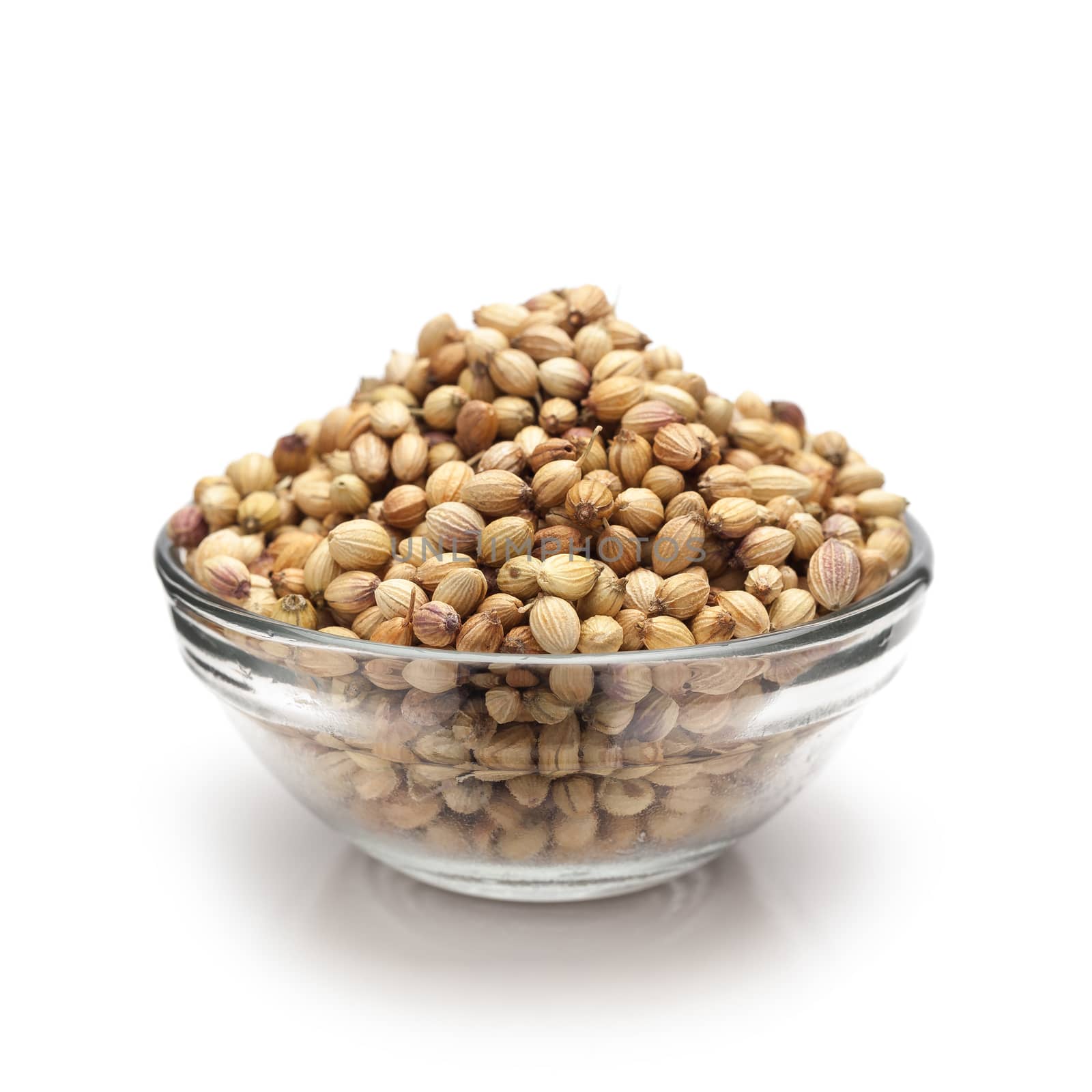 Front view of Organic Dried coriander seeds (Coriandrum sativum) in glass bowl isolated on white background.