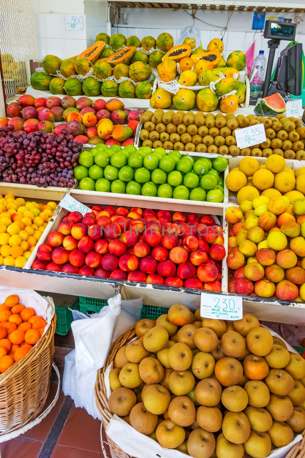 Funchal, Portugal - June 3, 2013: Market booth in Funchal, Madeira with different fruits. The market hall in Funchal is a popular tourist destination.