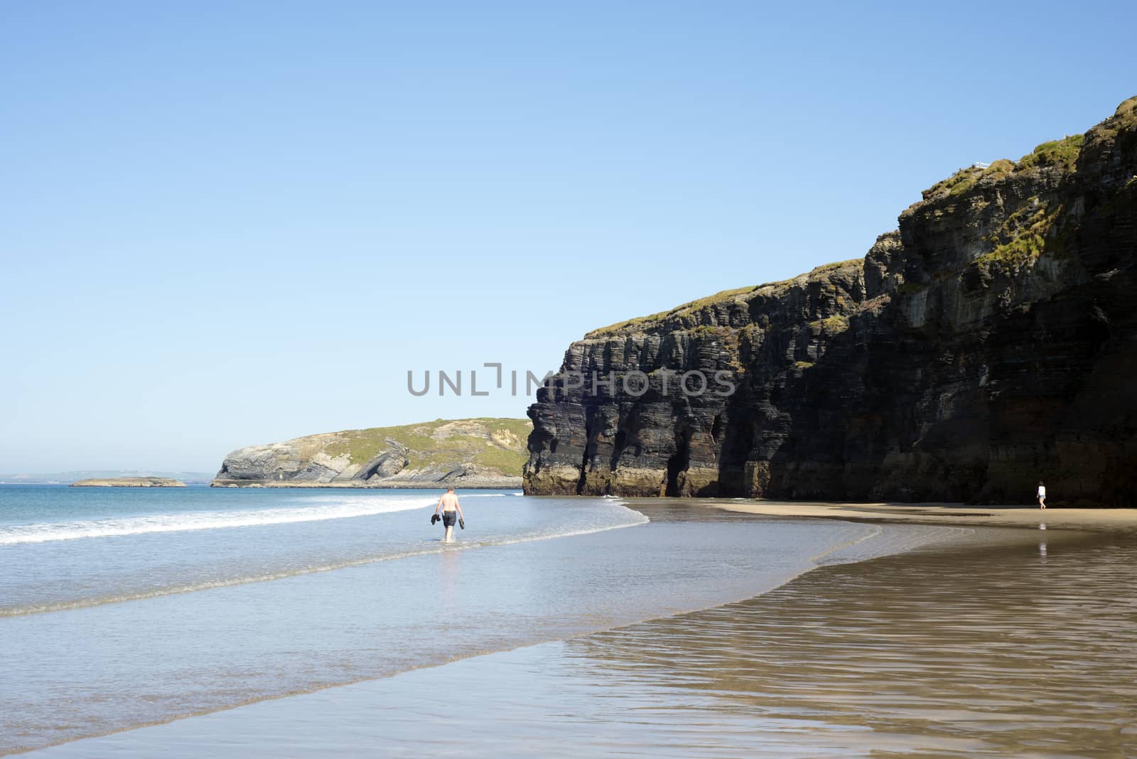 tourists in ballybunion beach and cliffs on the wild atlantic way at low tide