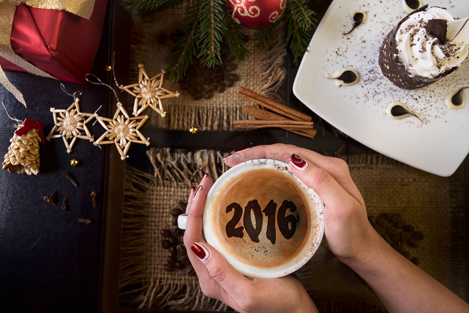 Hands holding mug of coffee close-up, on new year background