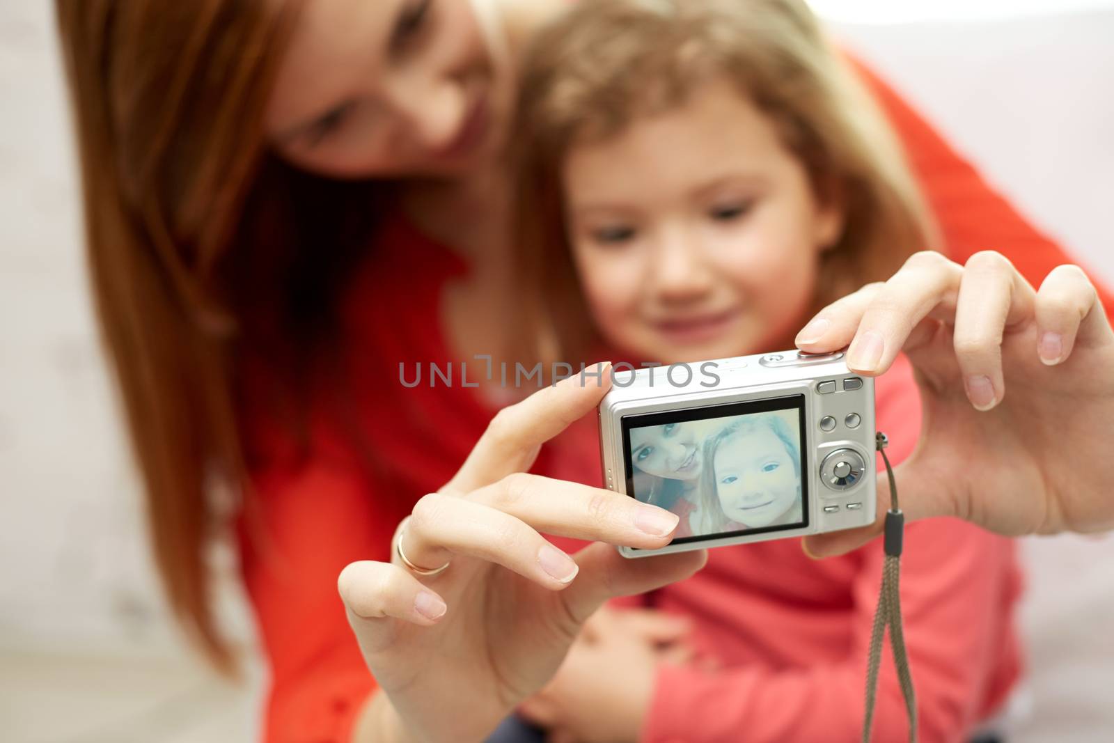 close up of happy mother and daughter with camera by dolgachov