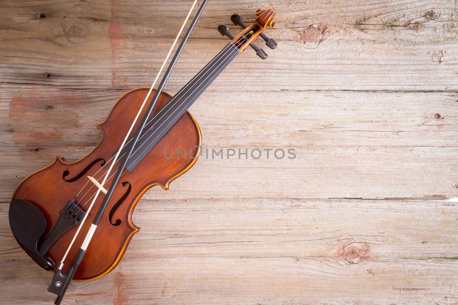 High Angle View of a Violin Musical Instrument Lying on a Wooden Floor with Copy Space on the Right Side.