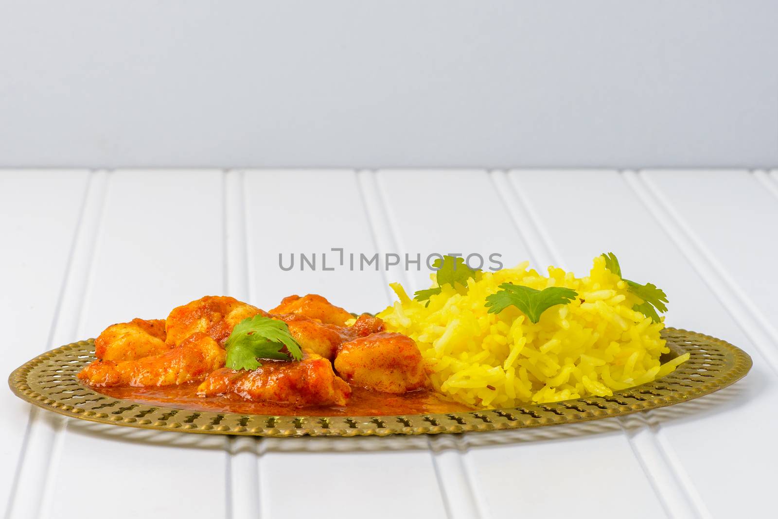 Plate of spicy chicken vindaloo served with basmati rice.