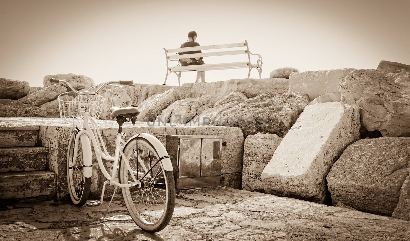 young girl sitting on the bench with her bicycle