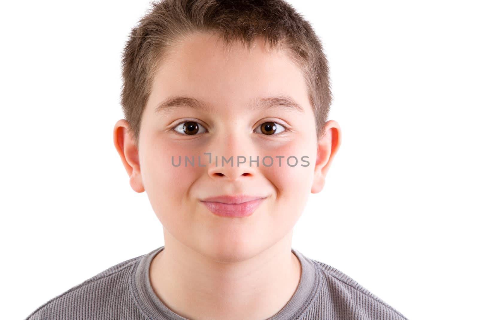 Head and Shoulders Close Up Portrait of Happy Young Boy Looking at Camera and Smiling with Wide Eyes in front of White Background