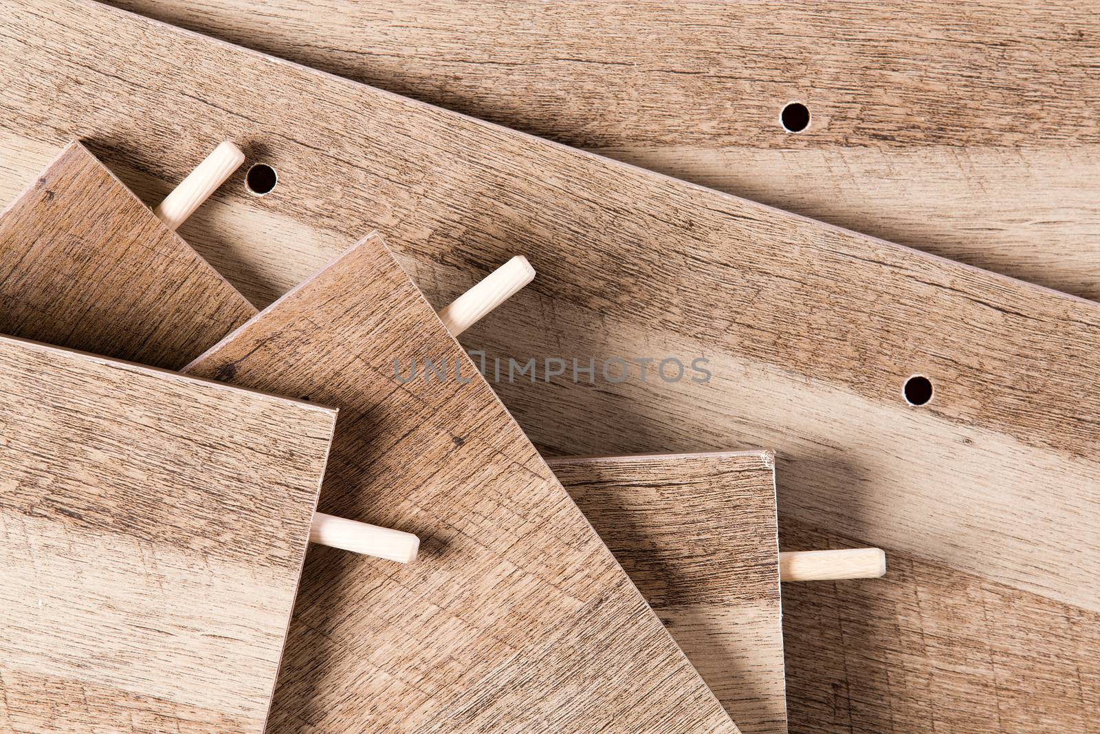 High Angle Close Up of Unfinished Wood Planks with Pegs and Holes - Background of Unassembled Wooden Shelves with Copy Space