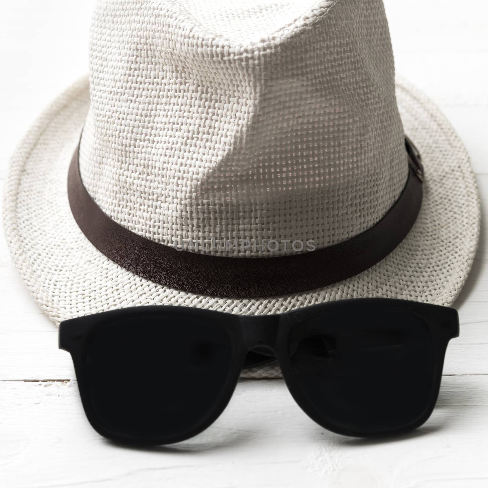 hat and sunglasses on white table