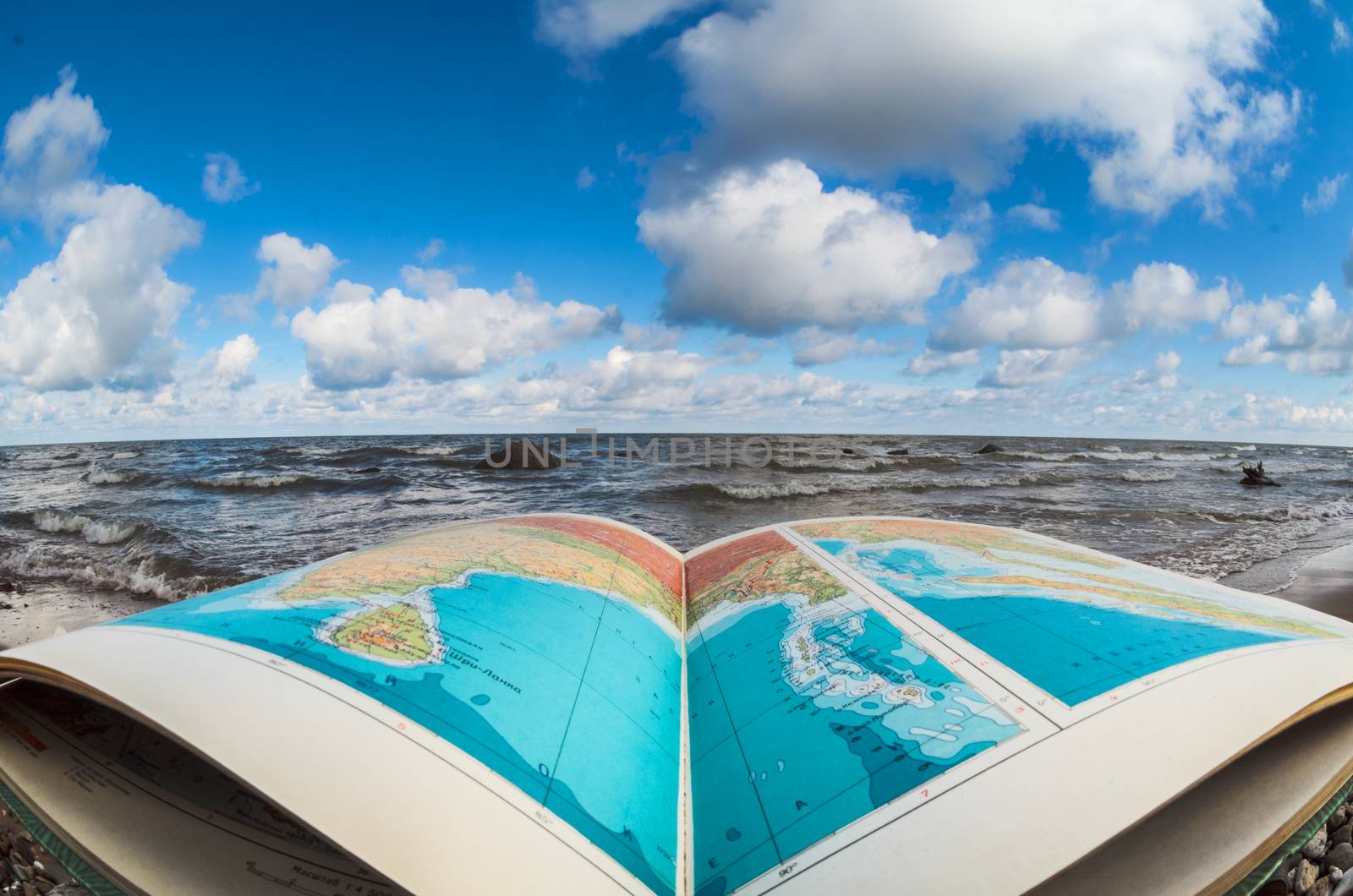 Opened atlas book at the seashore