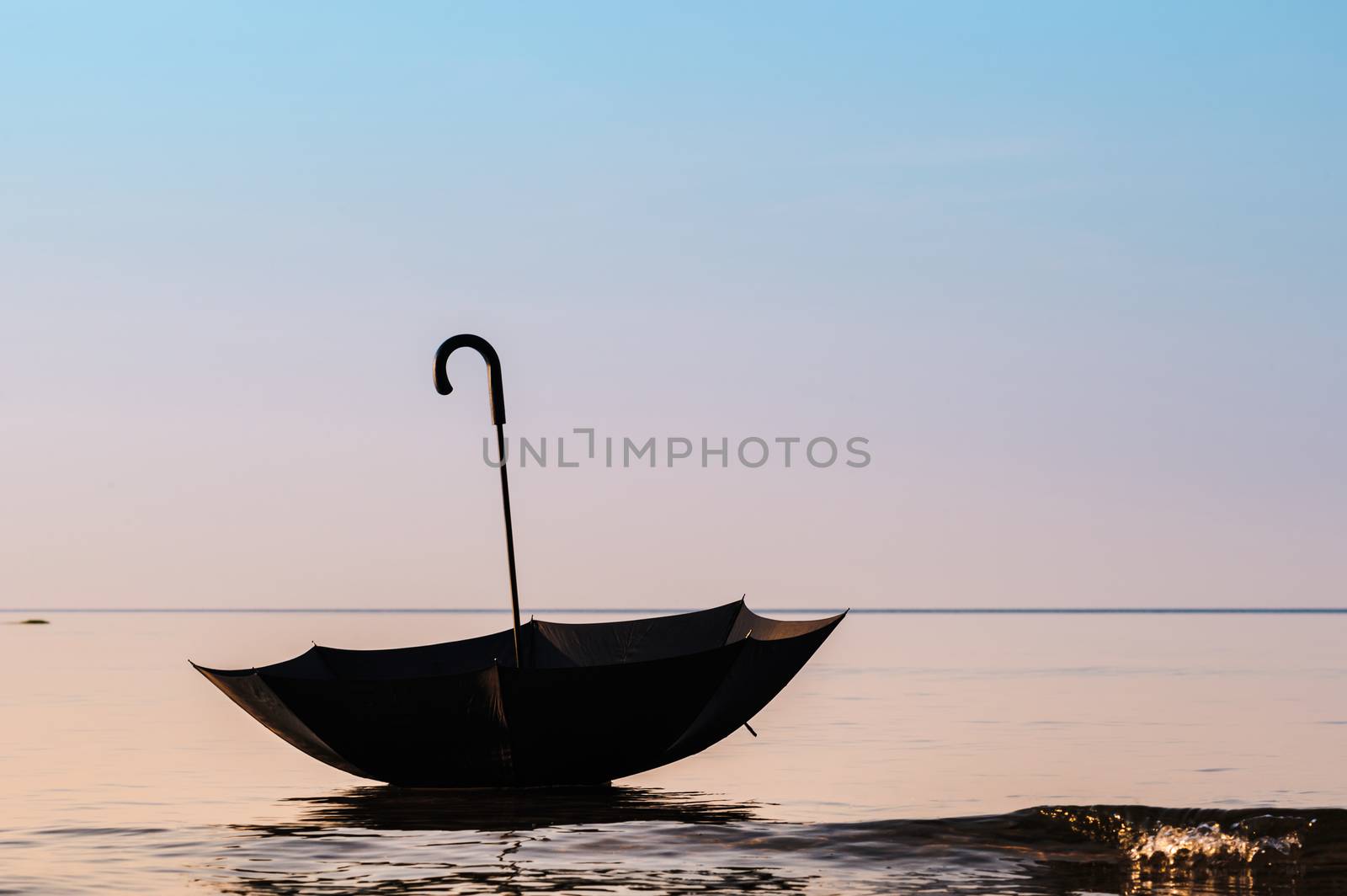 Open black umbrella on the sea surface