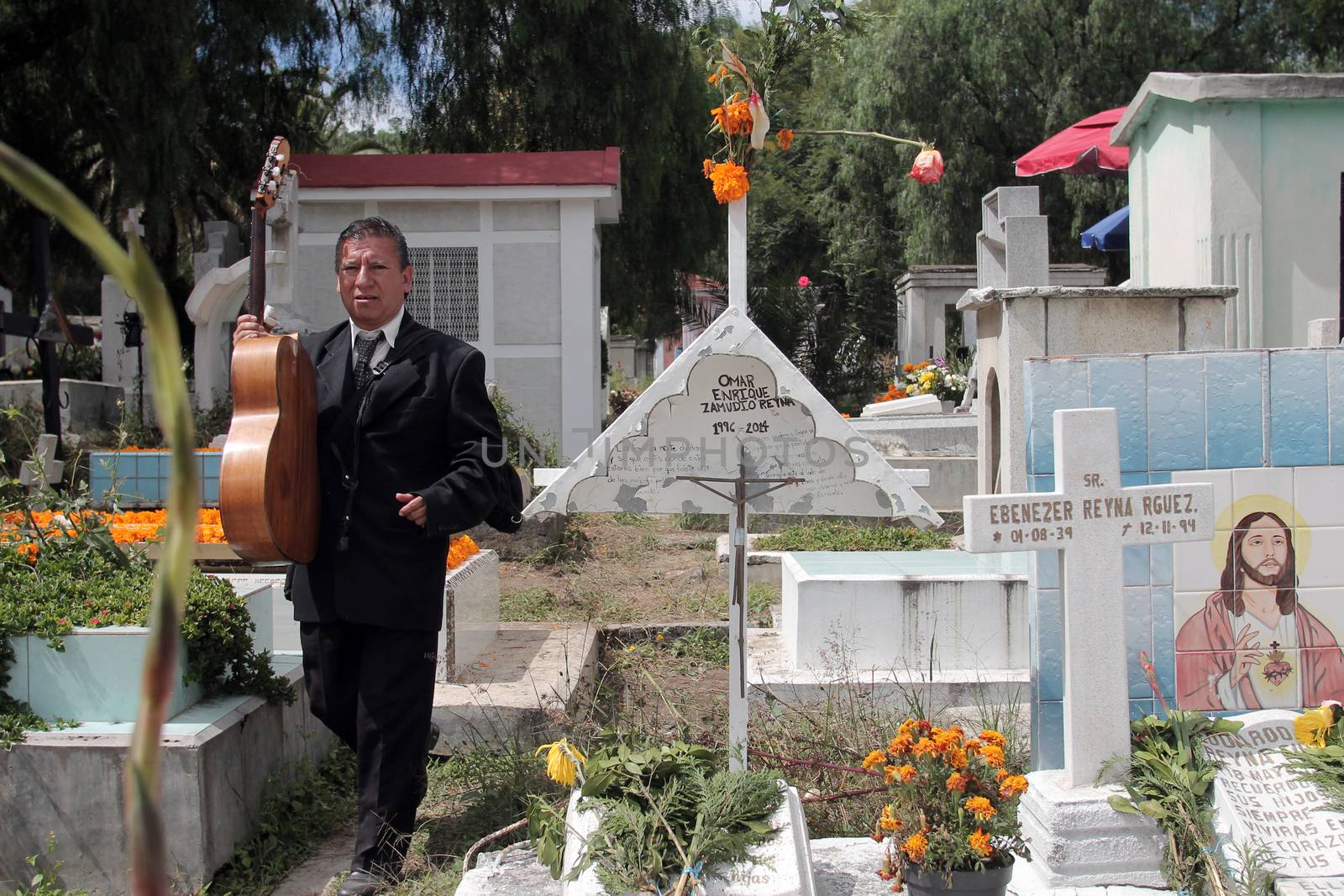 MEXICO, Mexico City: A man is about to play the guitar in front of a grave during the Day of the Dead ('Dia de los muertos' in spanish), in the cemetery of Iztapalapa, a huge district in eastern Mexico City, on November 2, 2015.