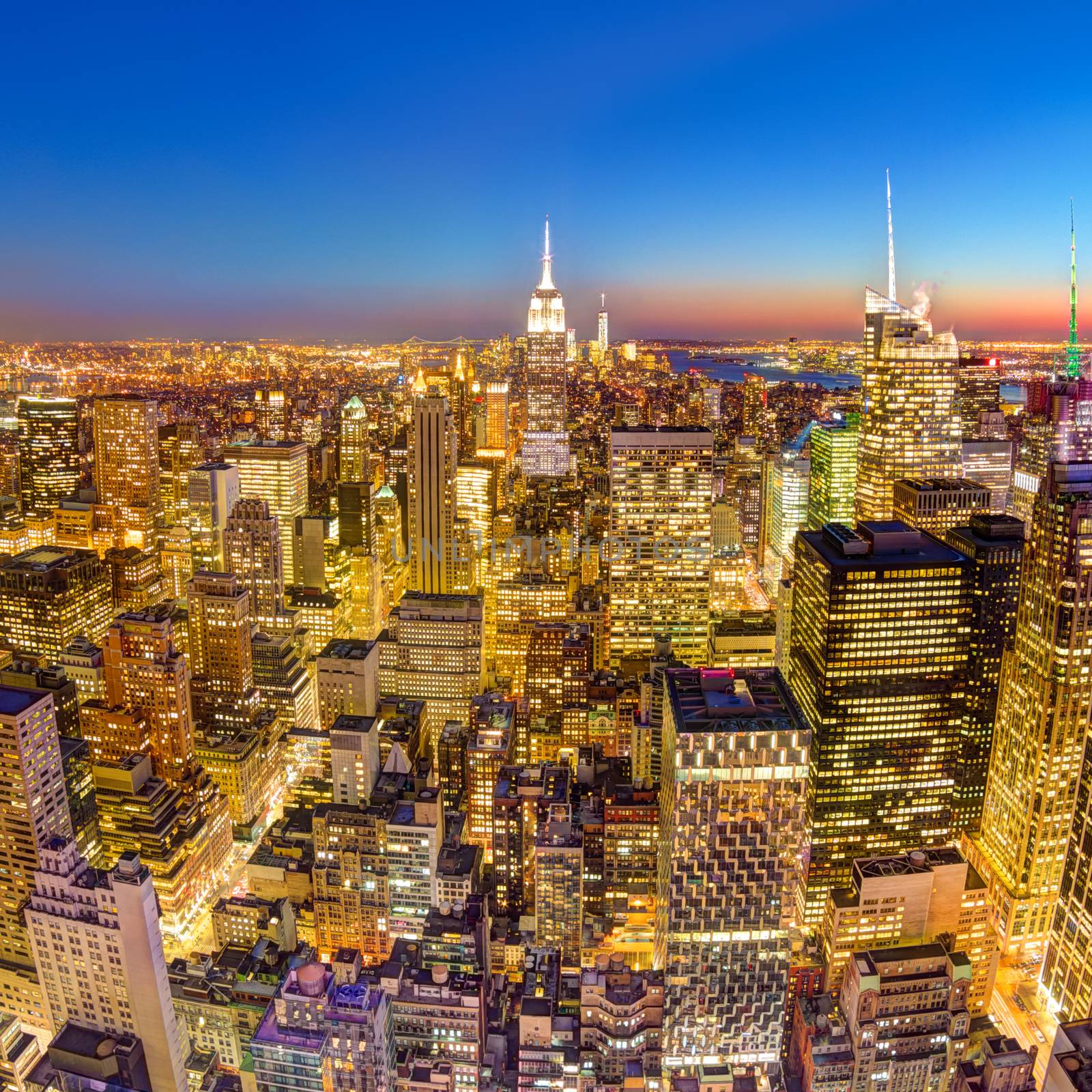 New York City. Manhattan downtown skyline with illuminated Empire State Building and skyscrapers at dusk. Square composition.