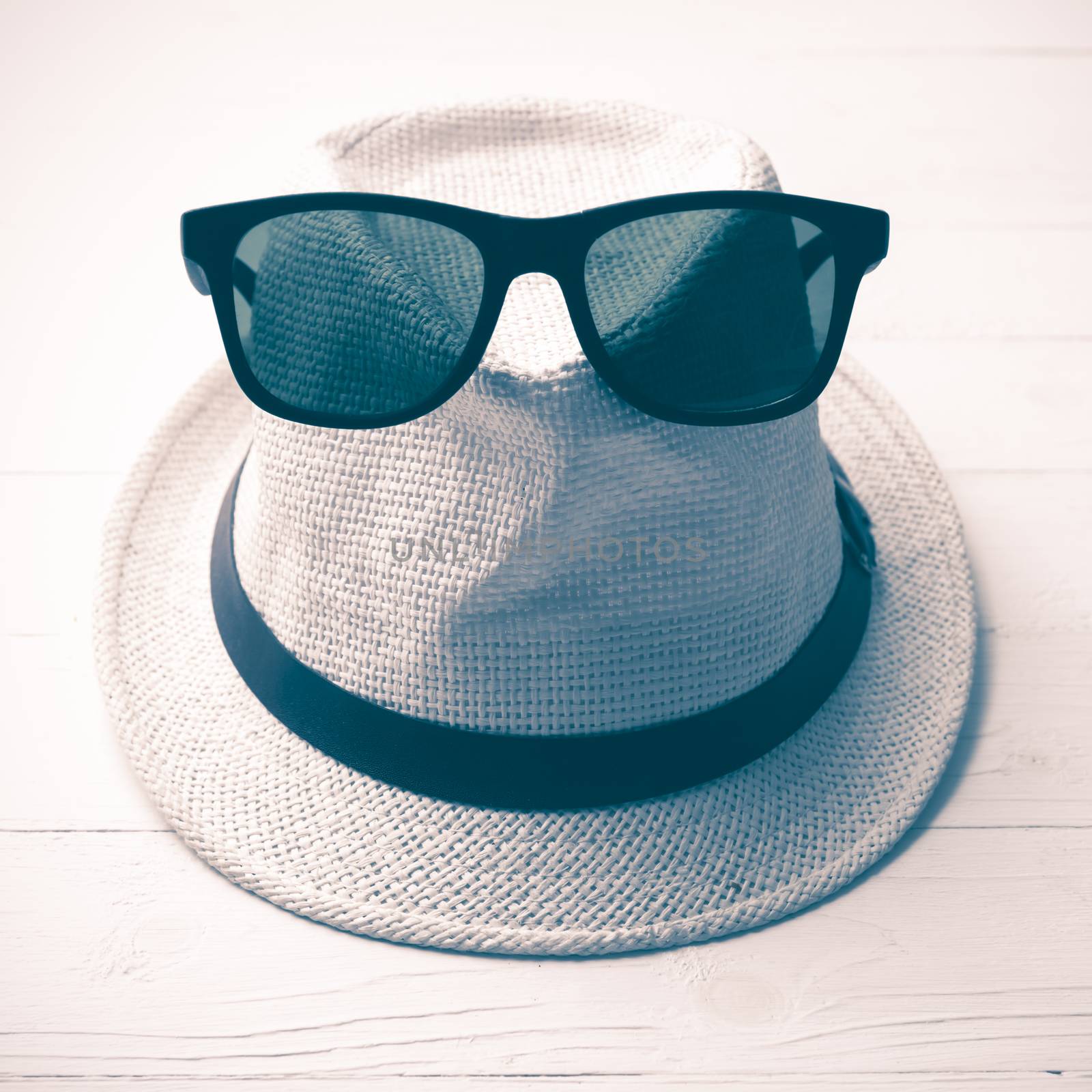 hat and sunglasses on white table vintage style