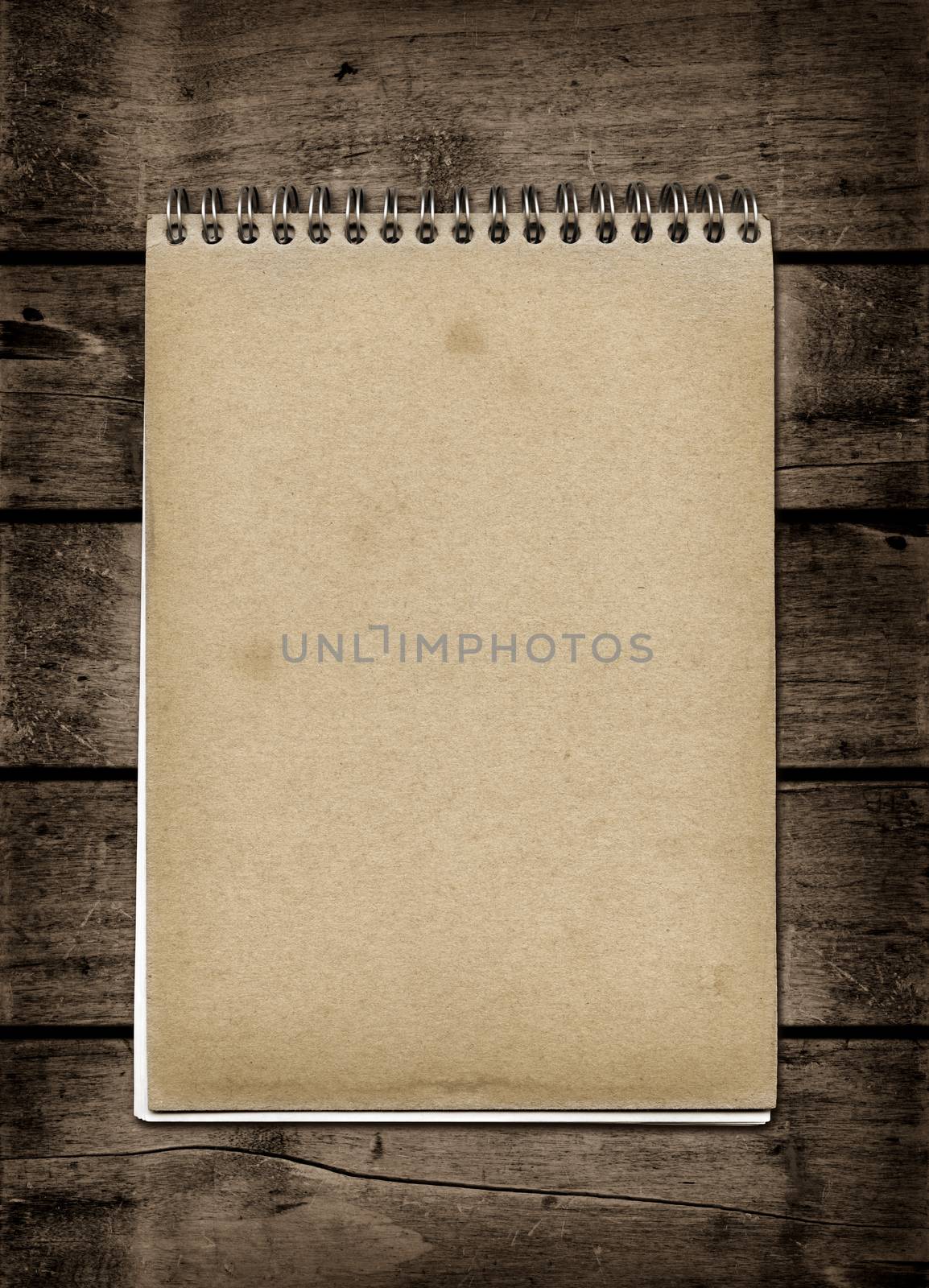 Closed spiral Note book on a dark wood table. Mockup