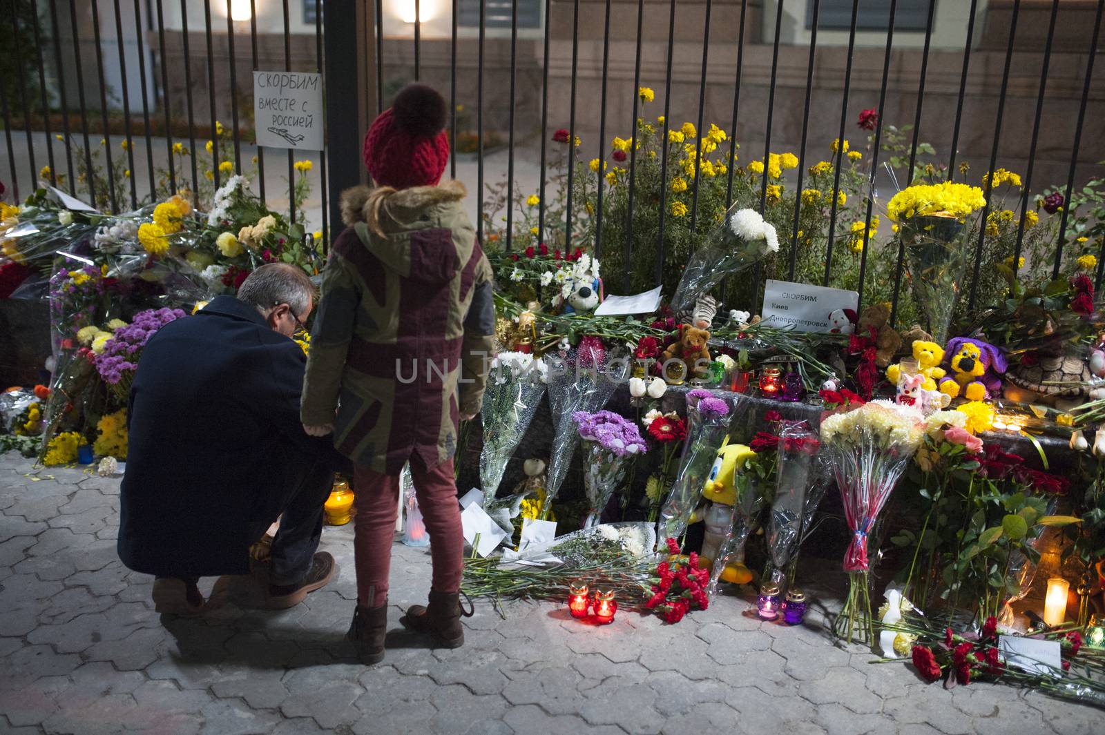 UKRAINE, Kiev: A man and a child lay flowers and put a candle outside the Russian embassy in Kiev, Ukraine, to pay tribute to the victims of crashed Russian Metrojet plane in Egypt, on November 1, 2015. The Airbus, with 224 people on board, crashed in a mountainous part of Egypt's Sinai Peninsula on October 31, 2015