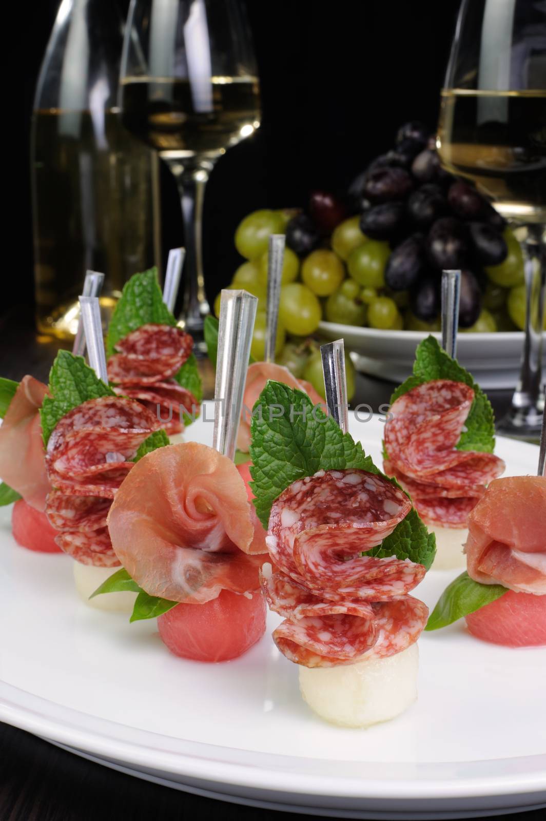 Canape of watermelon balls with a melon with gammon and salami