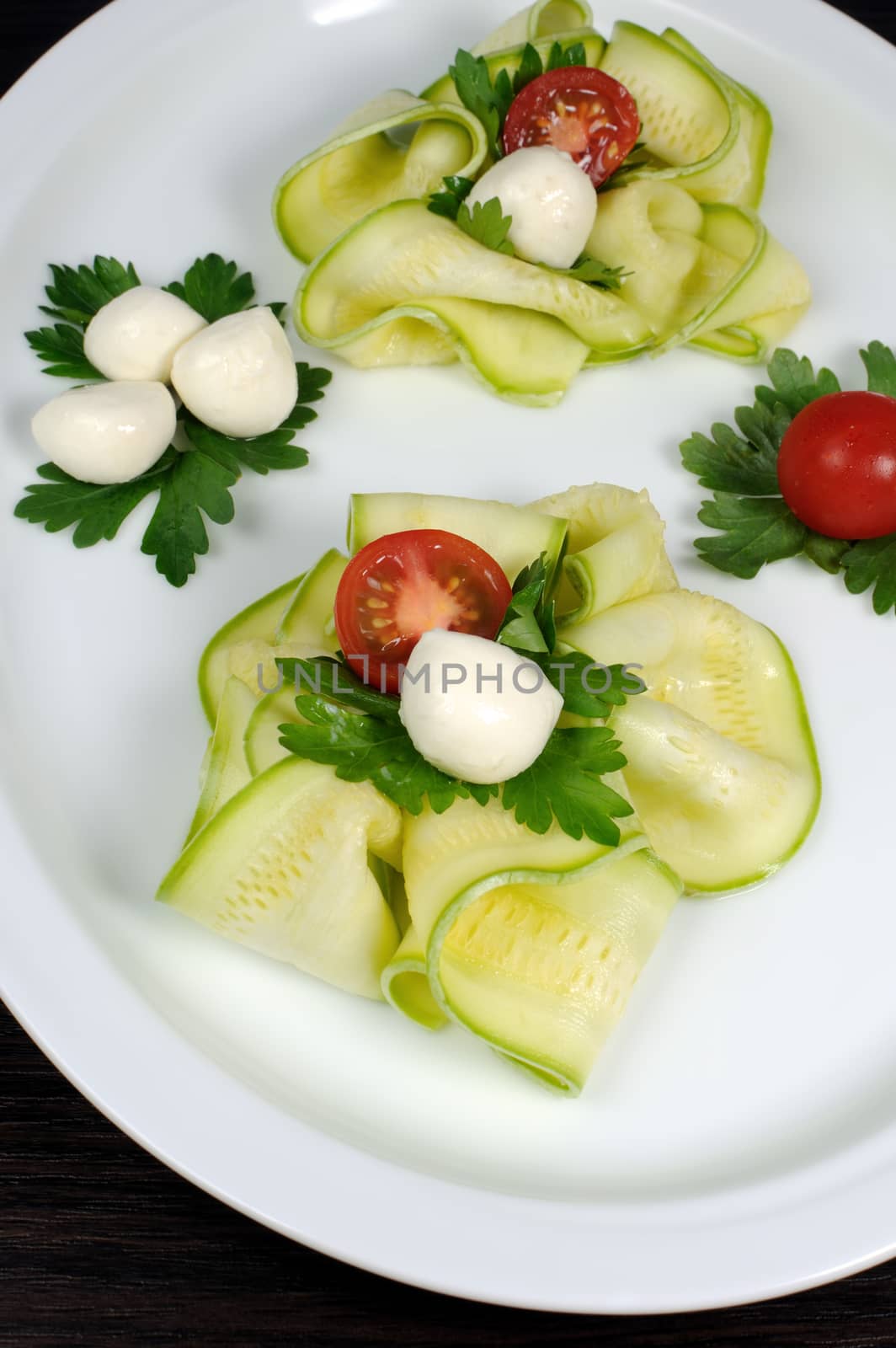 Snack in the form of roses from zucchini , mozzarella and cherry tomatoes