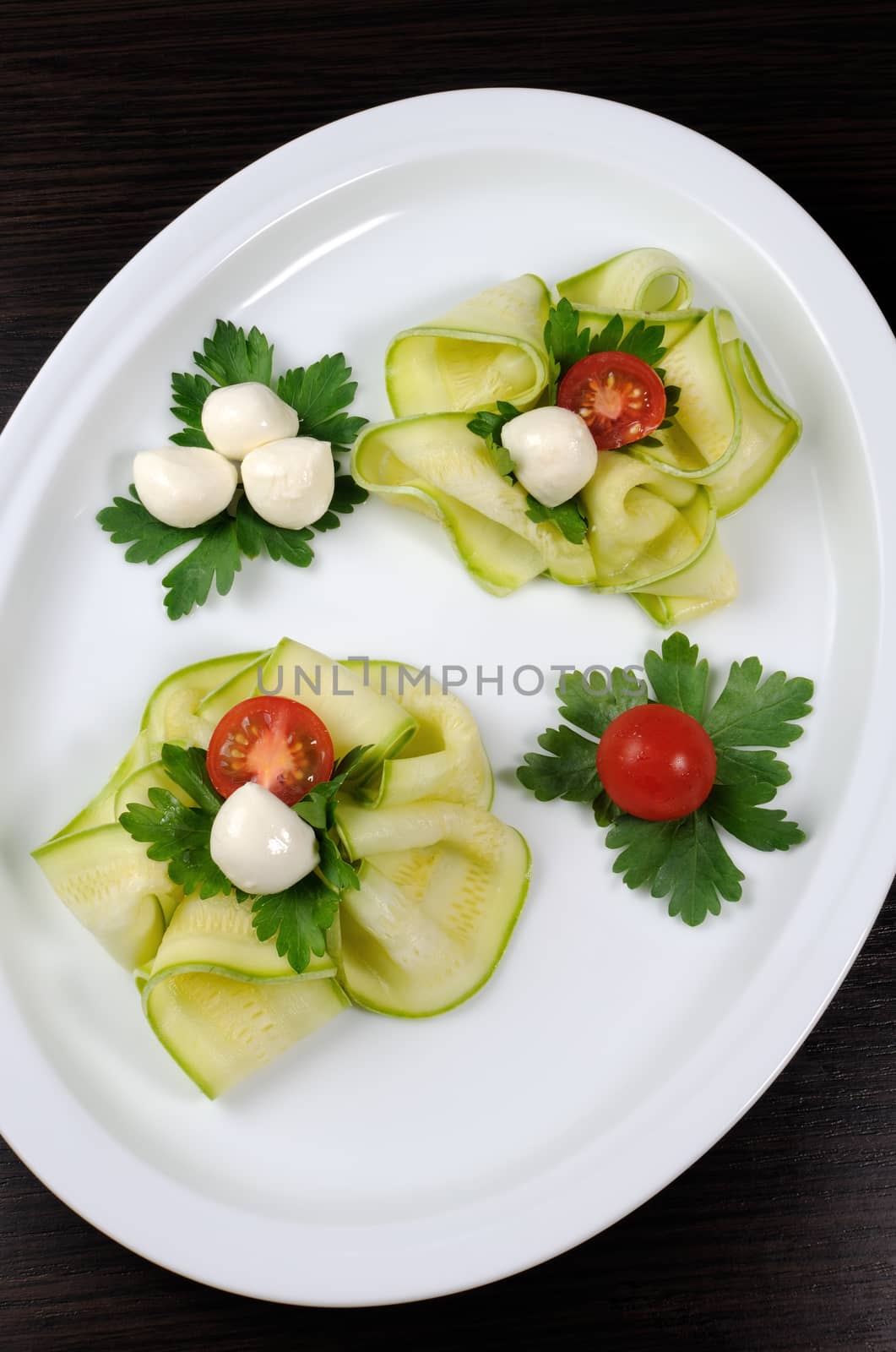 Snack in the form of roses from zucchini , mozzarella and cherry tomatoes