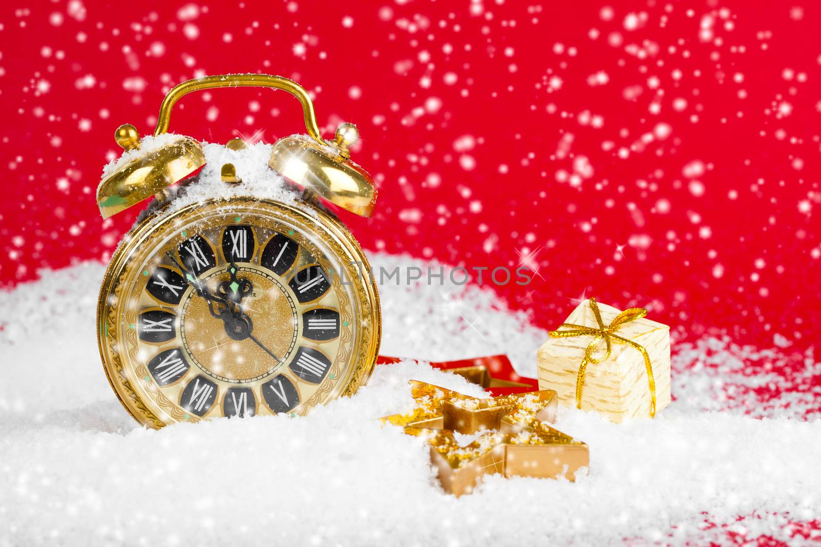 vintage christmas decoration golden star and antique golden clock in snow on red background