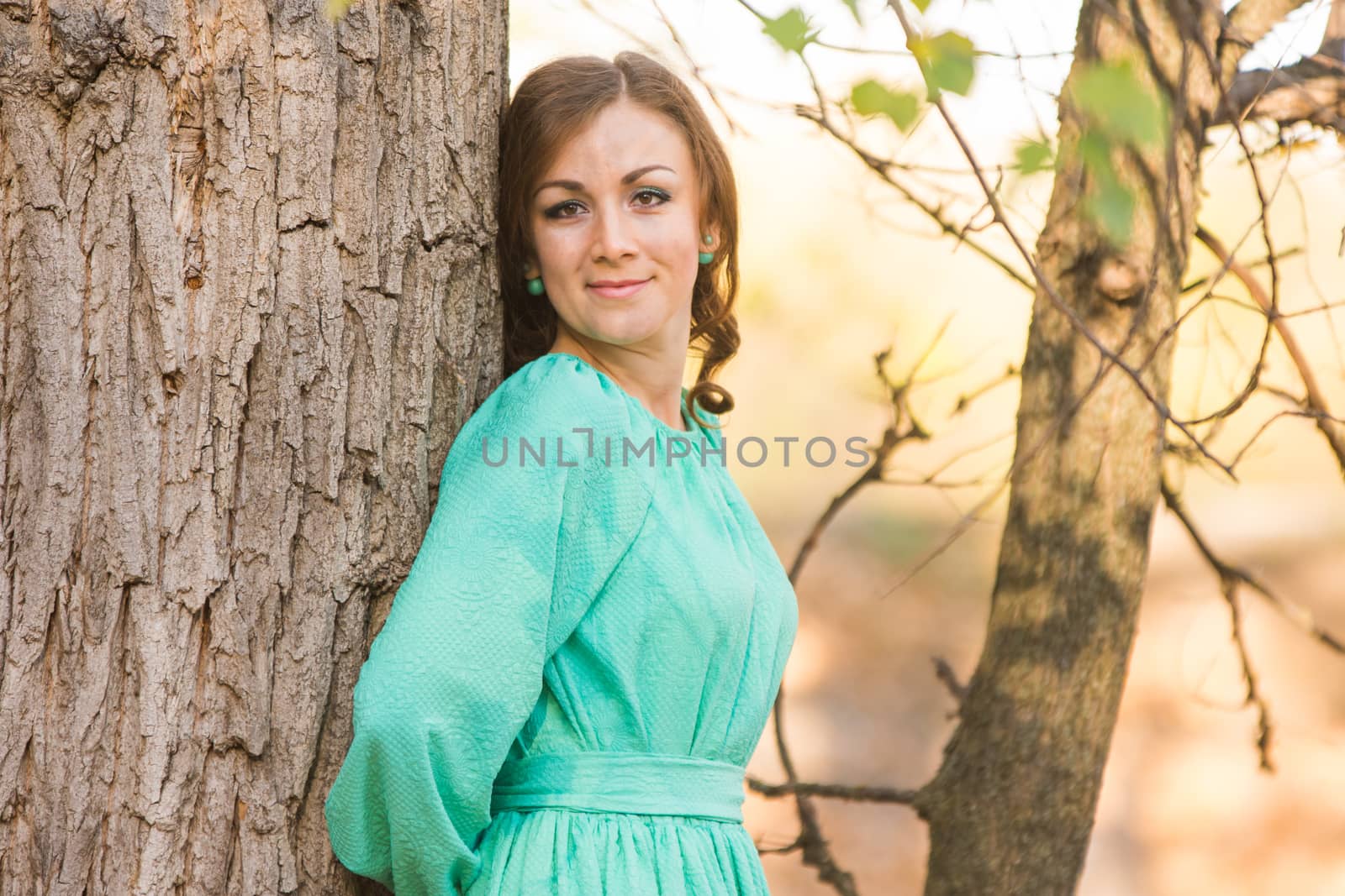 Young beautiful girl in a long dress walking in the woods on a warm summer day