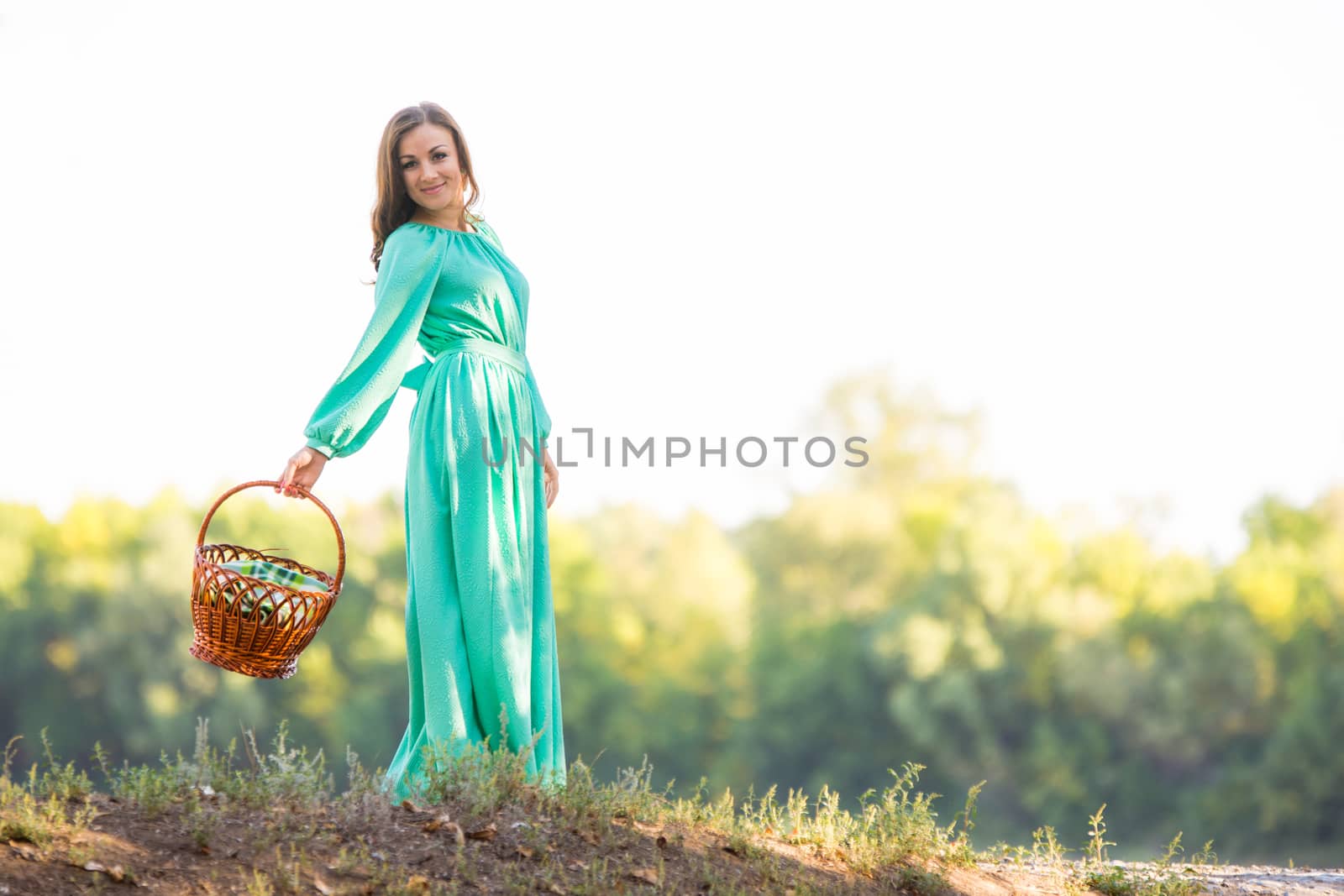 Young beautiful girl in a long dress walking in the woods on a warm summer day