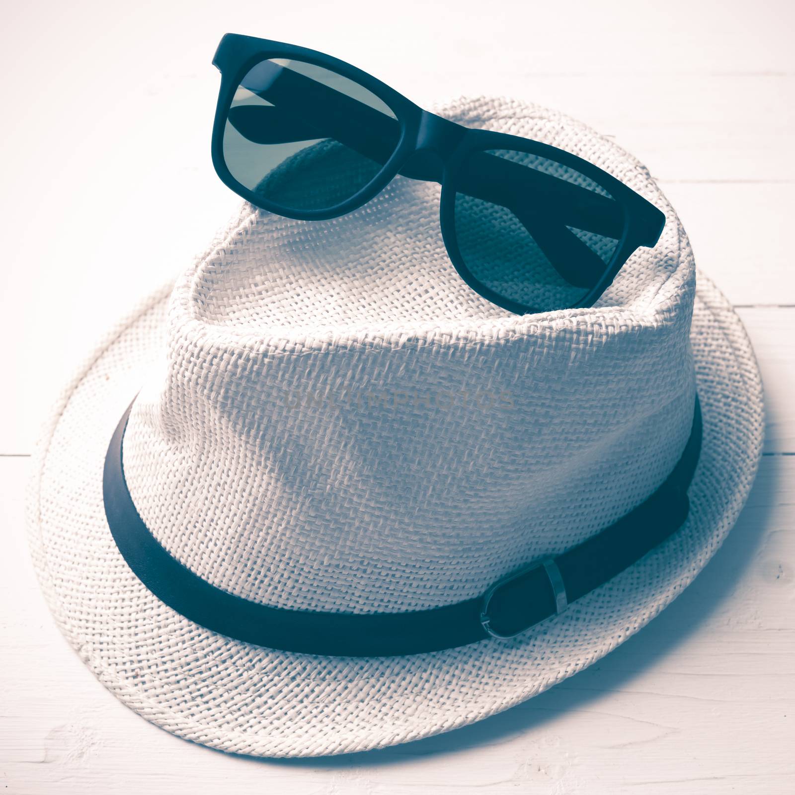 hat and sunglasses on white table vintage style