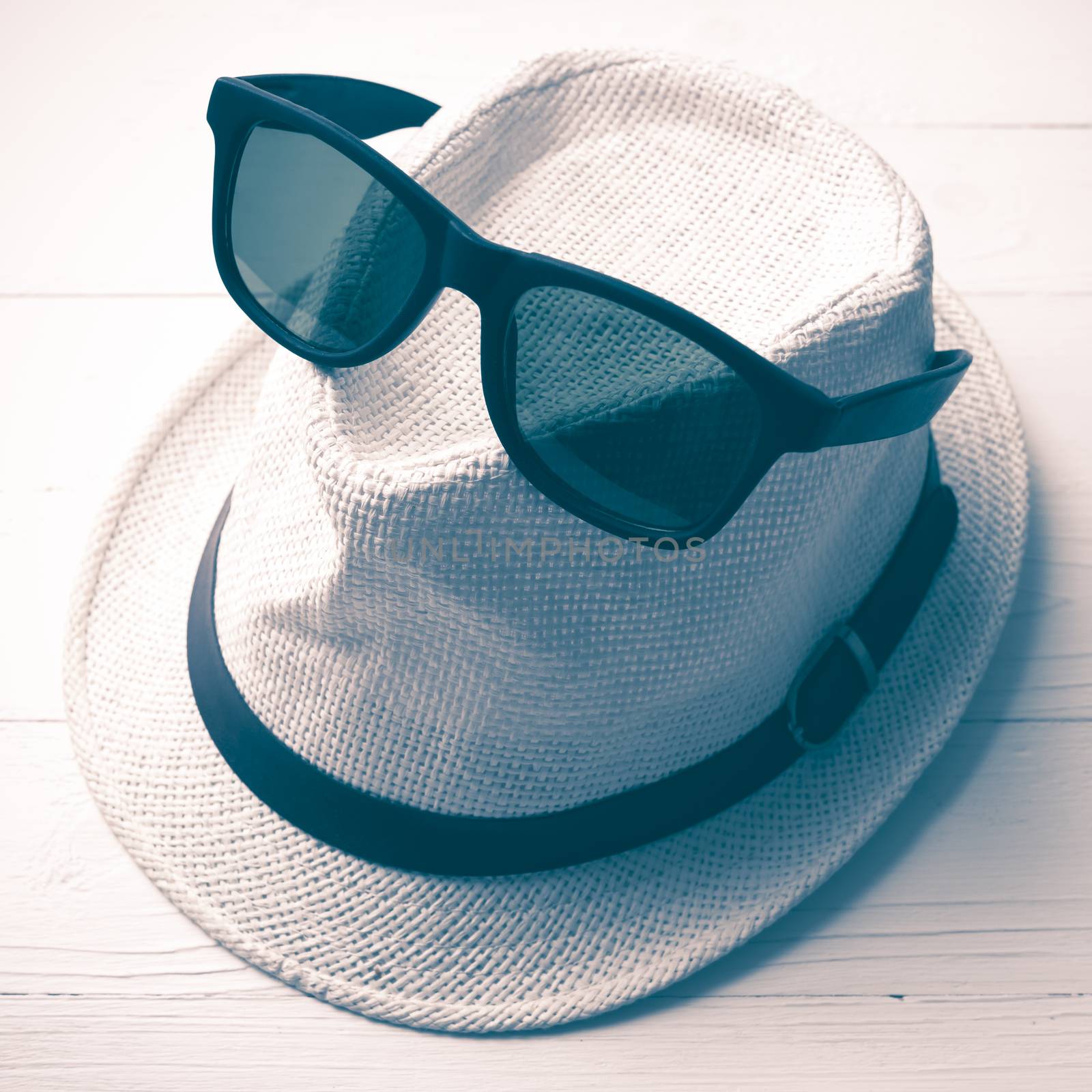 hat and sunglasses on white table vintage style