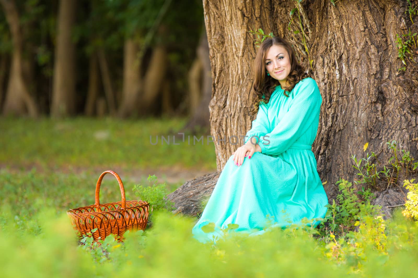 The young beautiful girl walks through the forest on a warm summer day