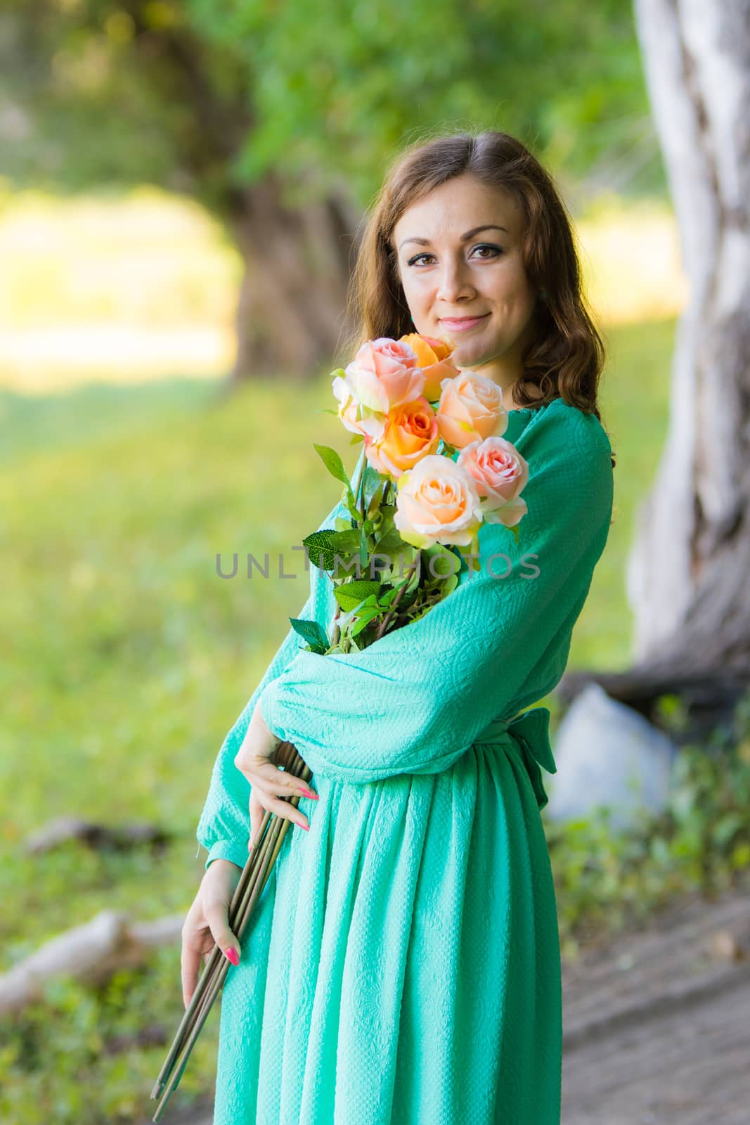 Young beautiful girl in a long dress walking in the woods on a warm summer day