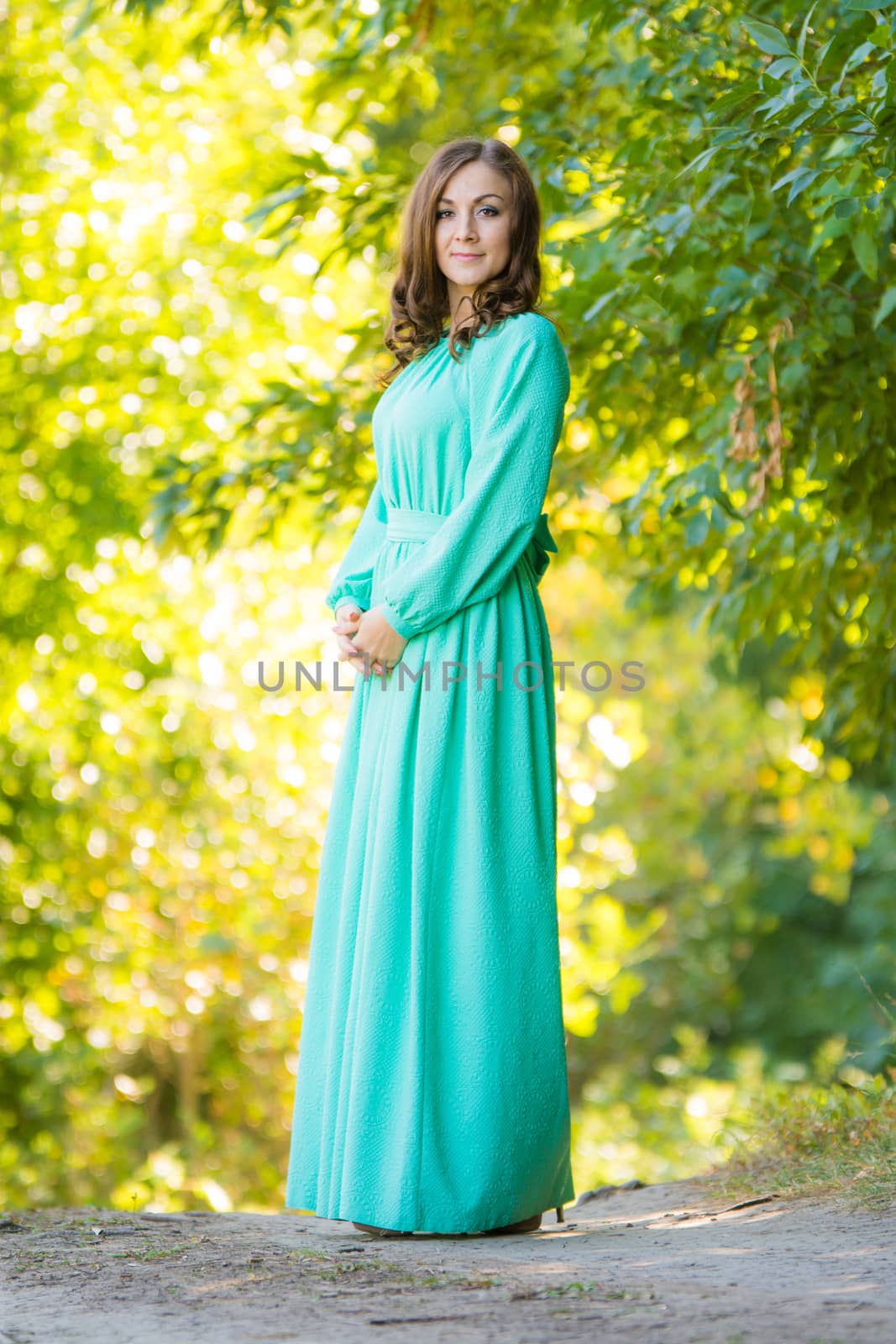 The young beautiful girl walks through the forest on a warm summer day