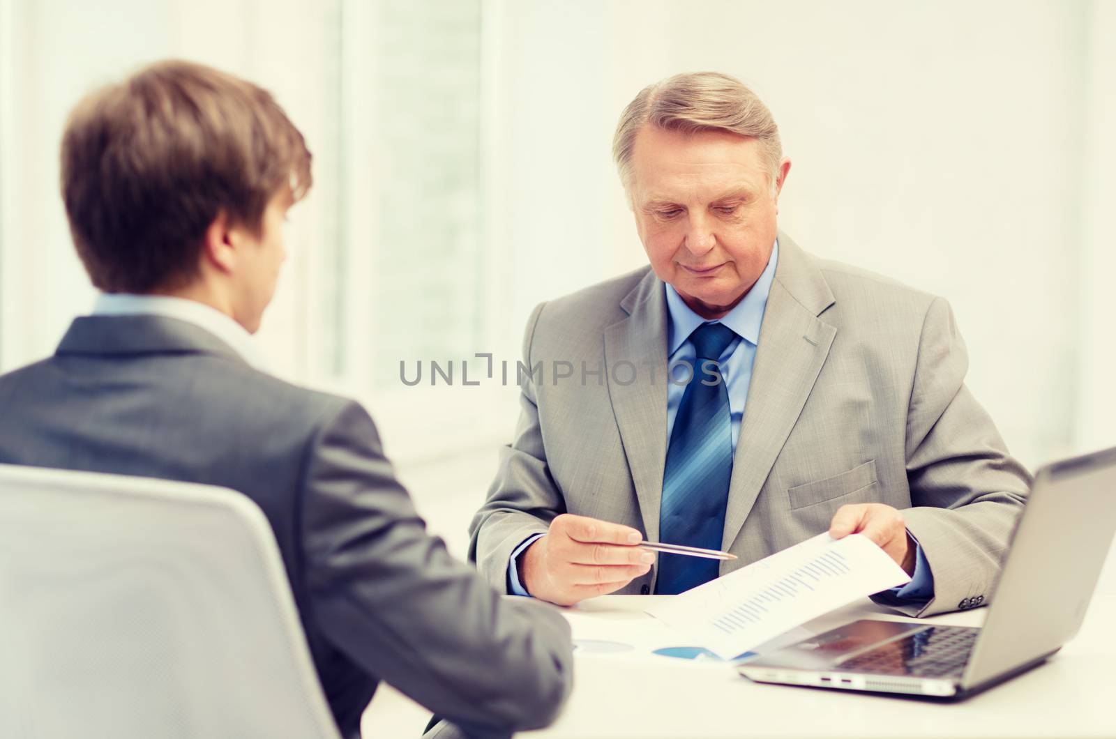 older man and young man having meeting in office by dolgachov