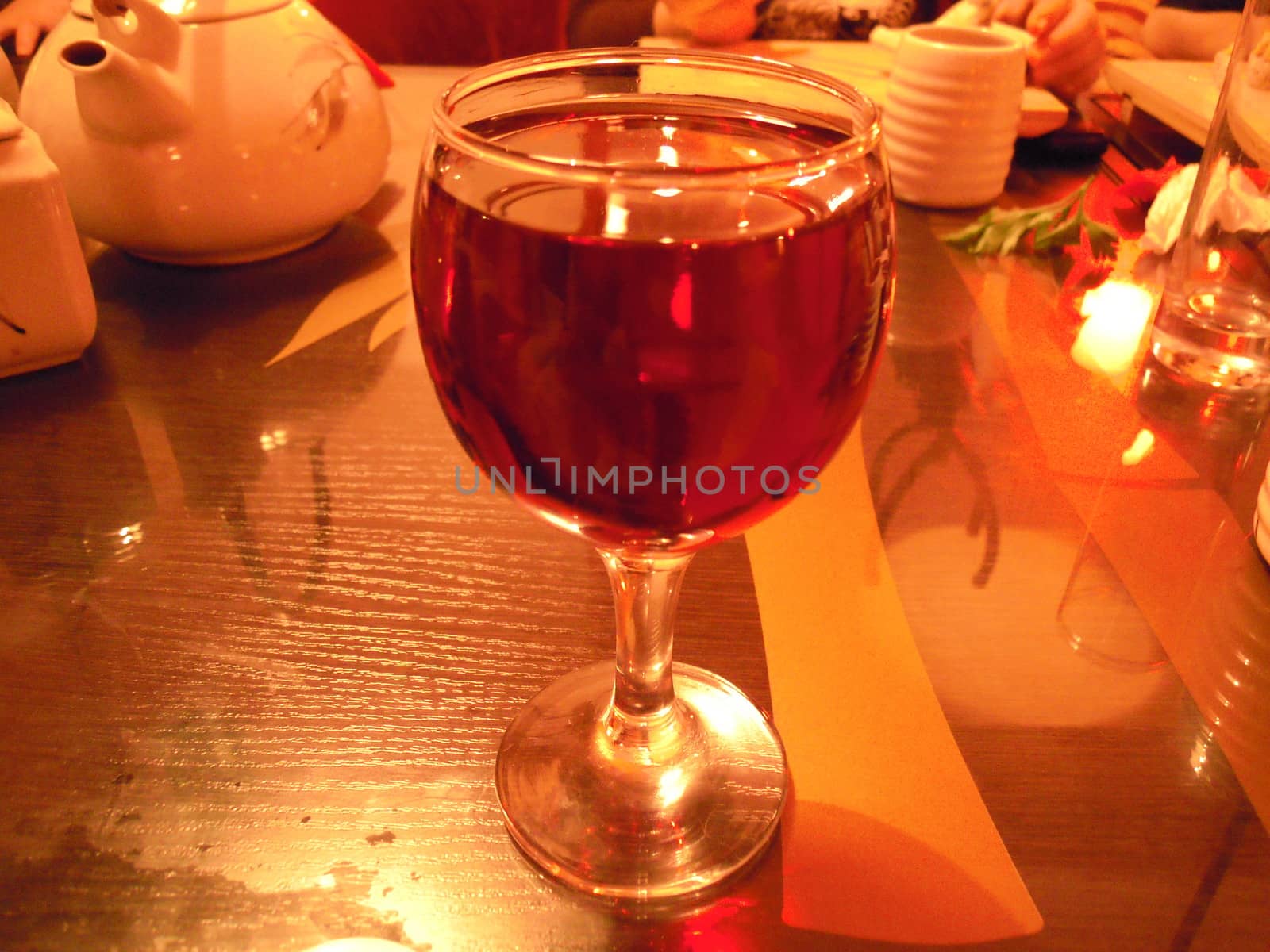 glass of red wine is on the table in a bar by olga_ovchinnikova