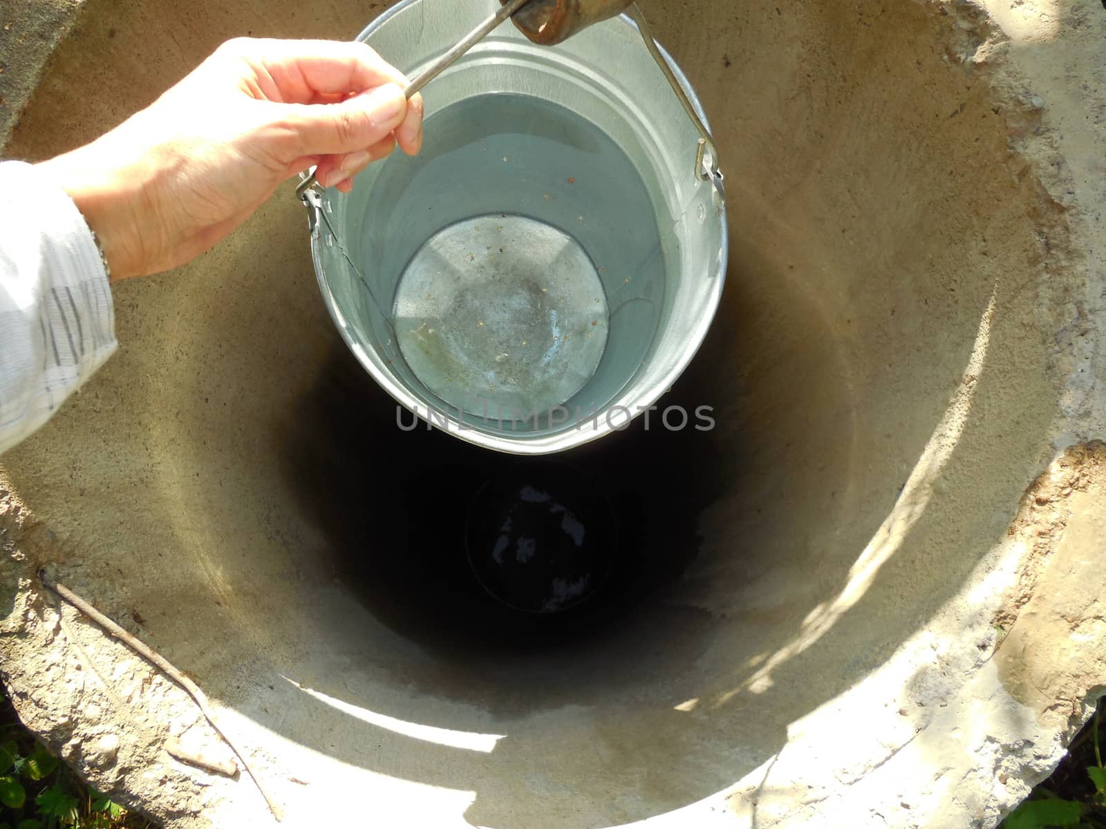 a bucket of water, lifted out of the well in the Pskov region, Russia.
