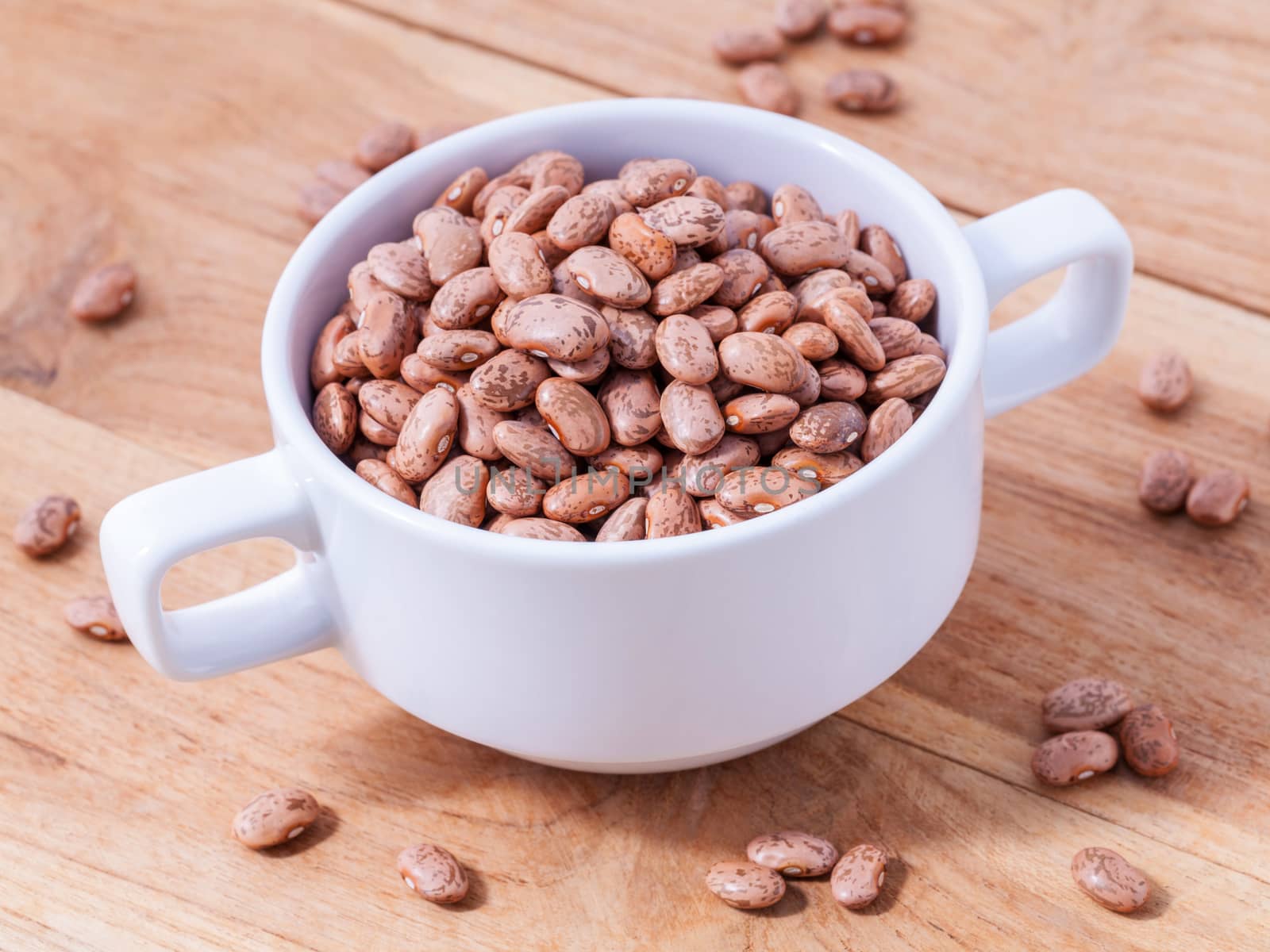 Brown pinto beans in the bowl and brown pinto beans  background.