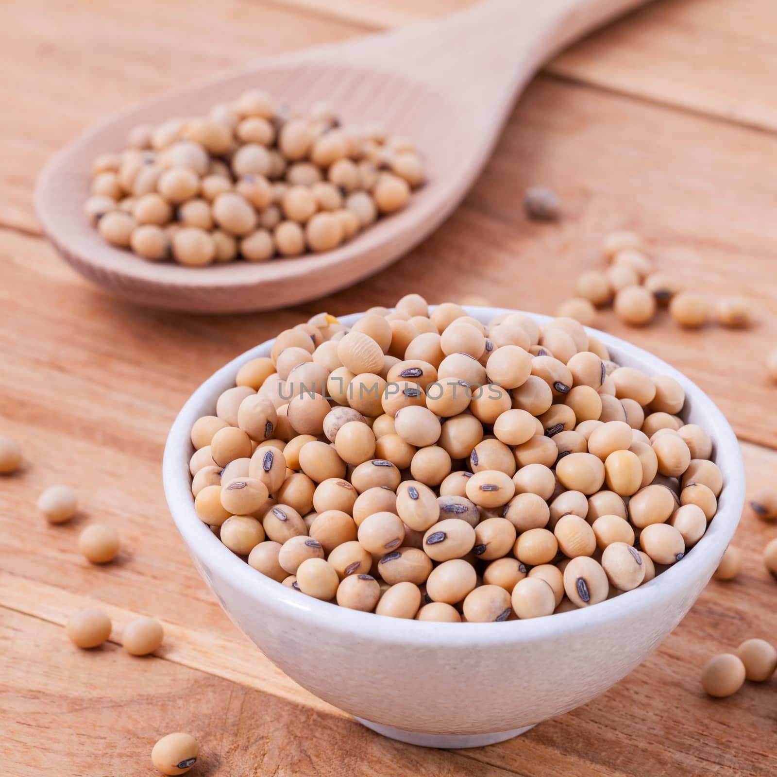 Close Up soy beans in wooden bowl and spoon on wooden background by kerdkanno