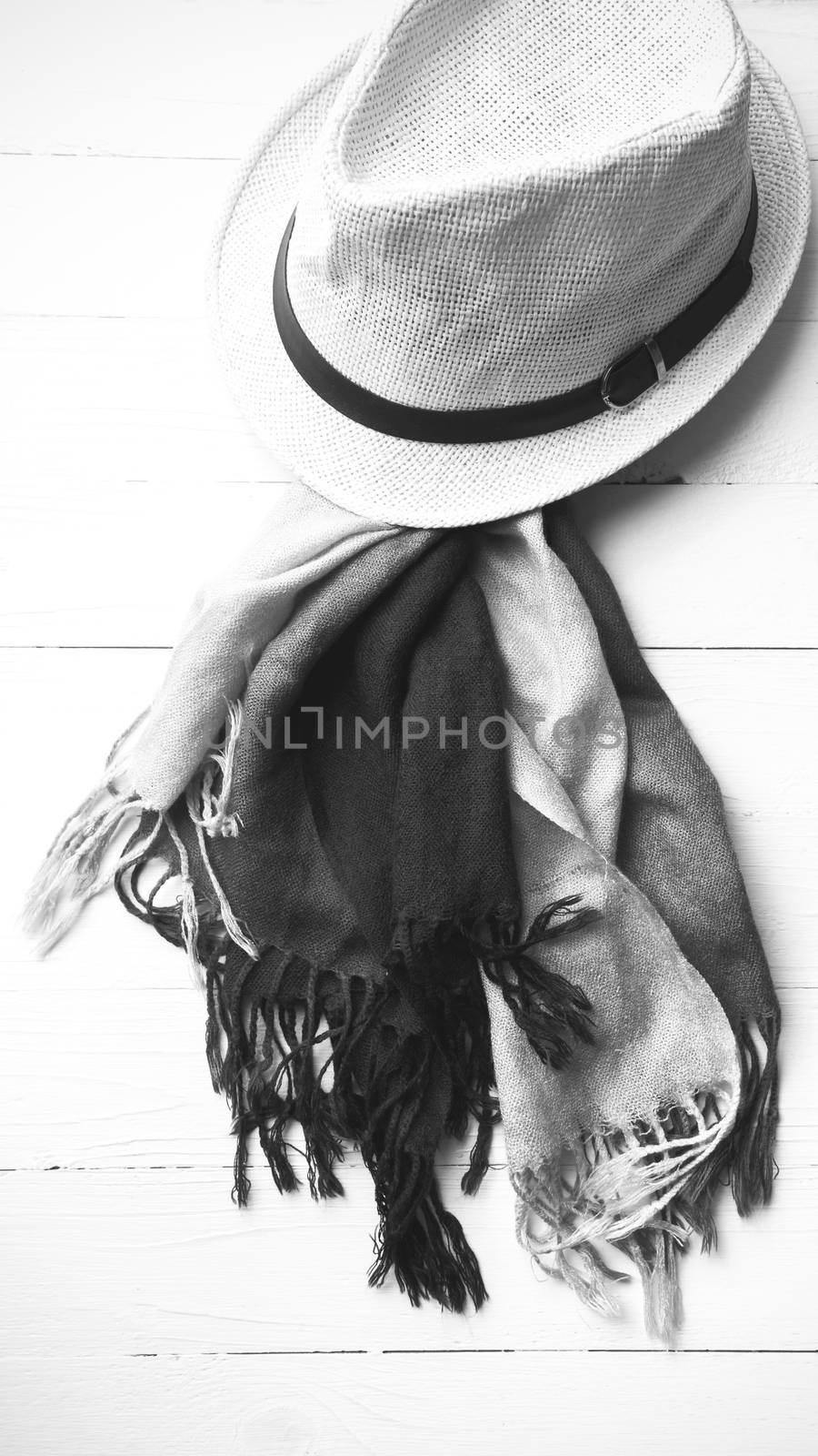 hat and blue scarf on white table black and white color