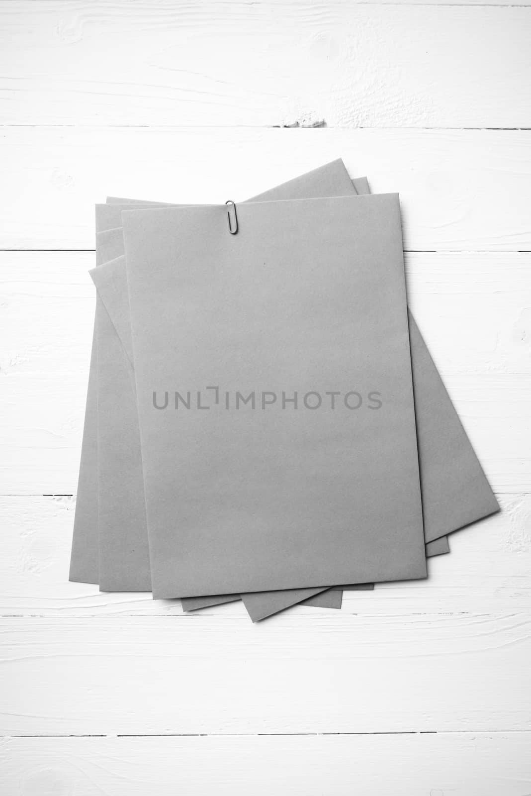 brown paper with green paper clip over white table black and white color