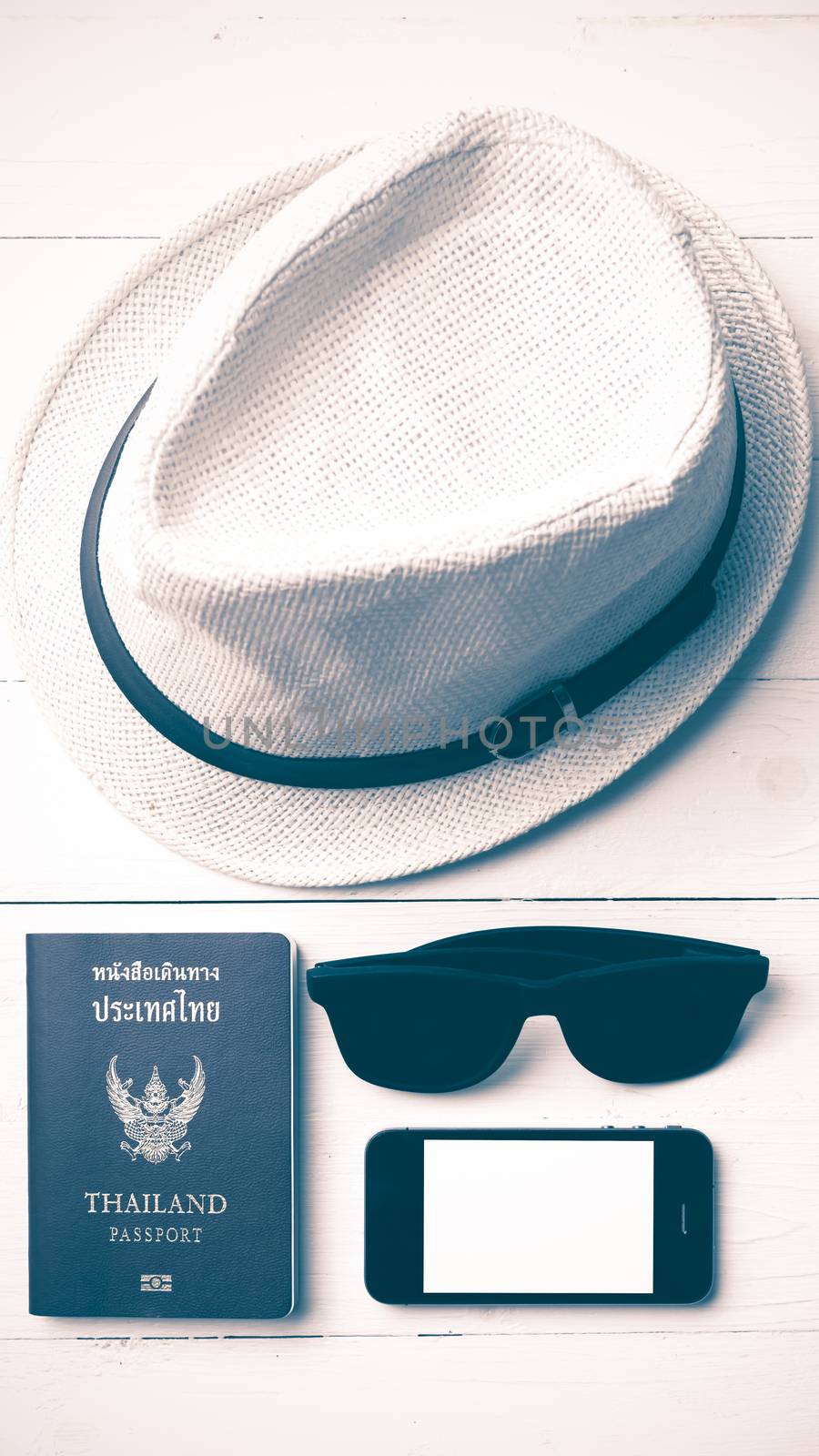 hat sunglasses smart phone and passport over white table vintage style