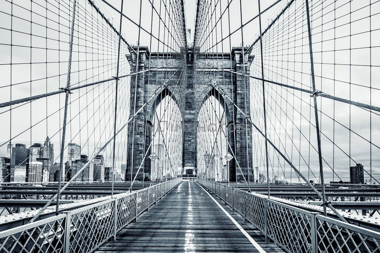 New York City Brooklyn Bridge in Manhattan closeup with skyscrapers and city skyline over Hudson River. Black and white.