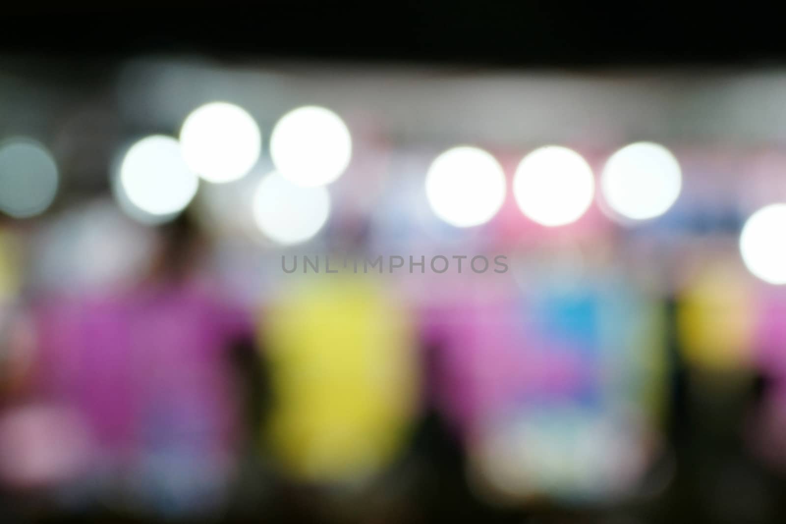 Defocused and blurred image of people at amusement park at night for background usage. by mranucha
