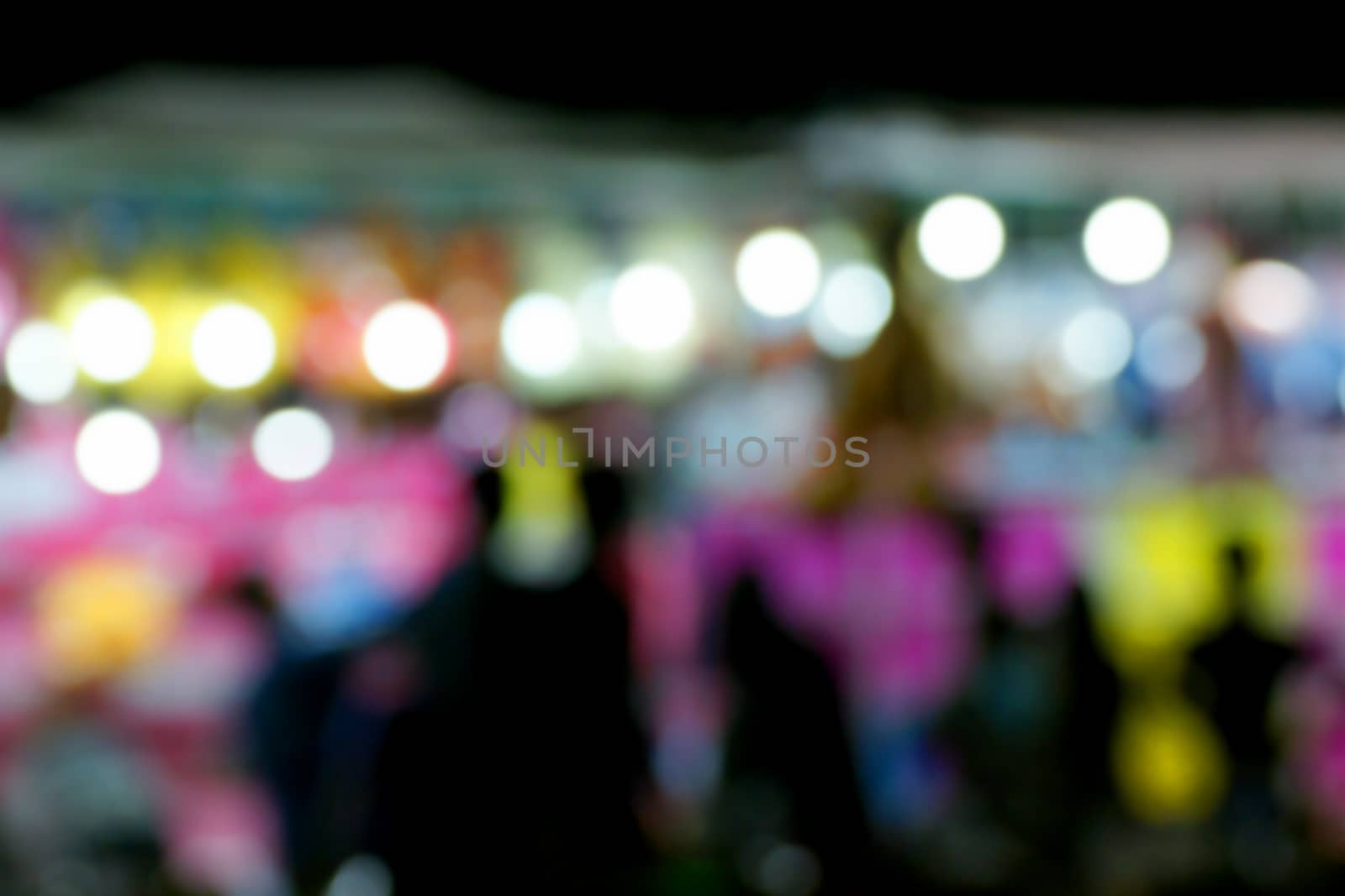 Defocused and blurred image of people at amusement park at night for background usage. by mranucha