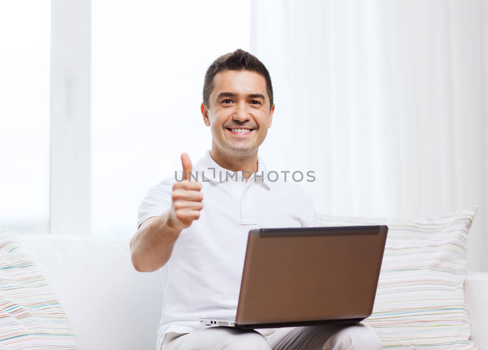 technology, people lifestyle and networking concept - happy man with laptop computer showing thumbs up at home