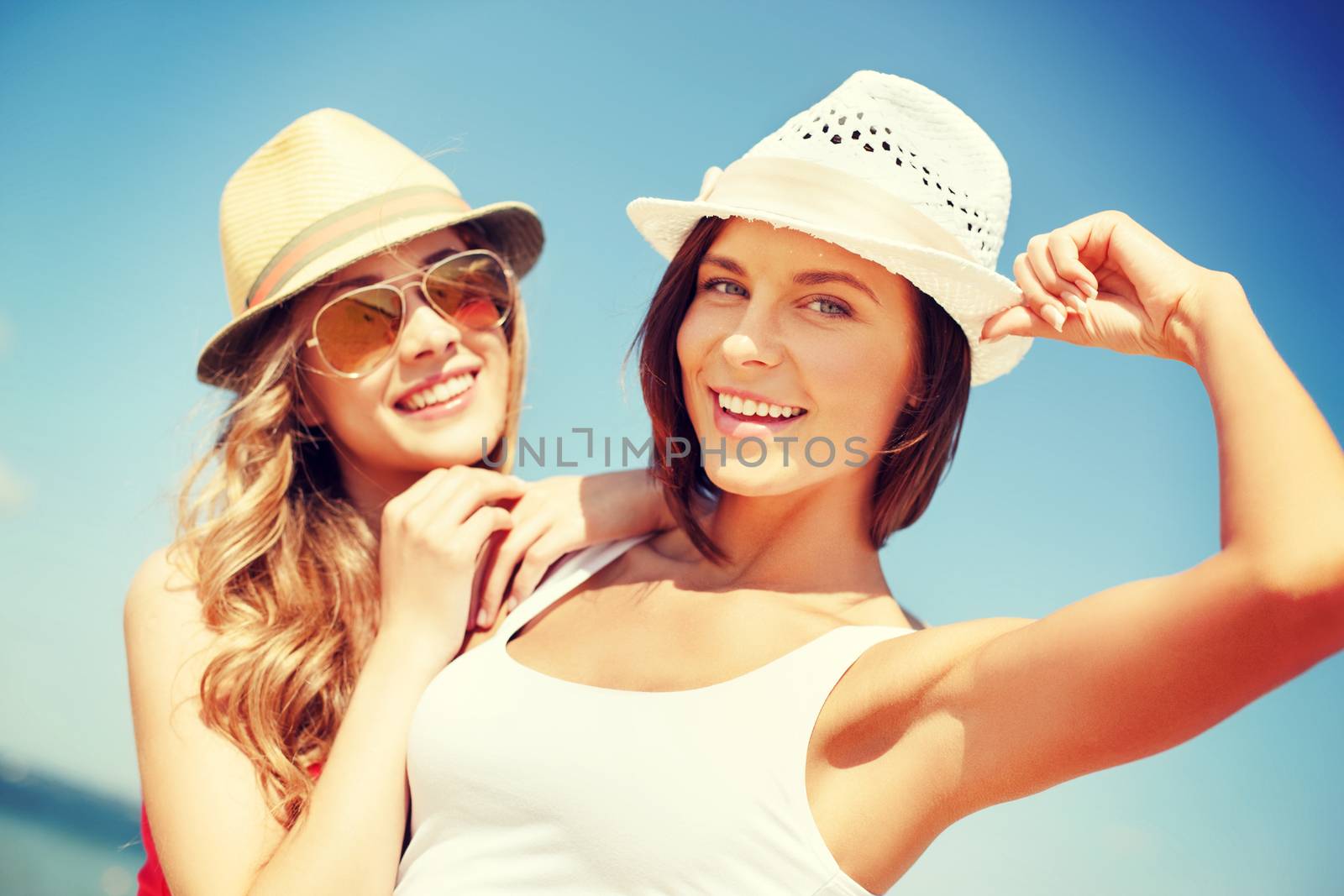 girls in hats on the beach by dolgachov