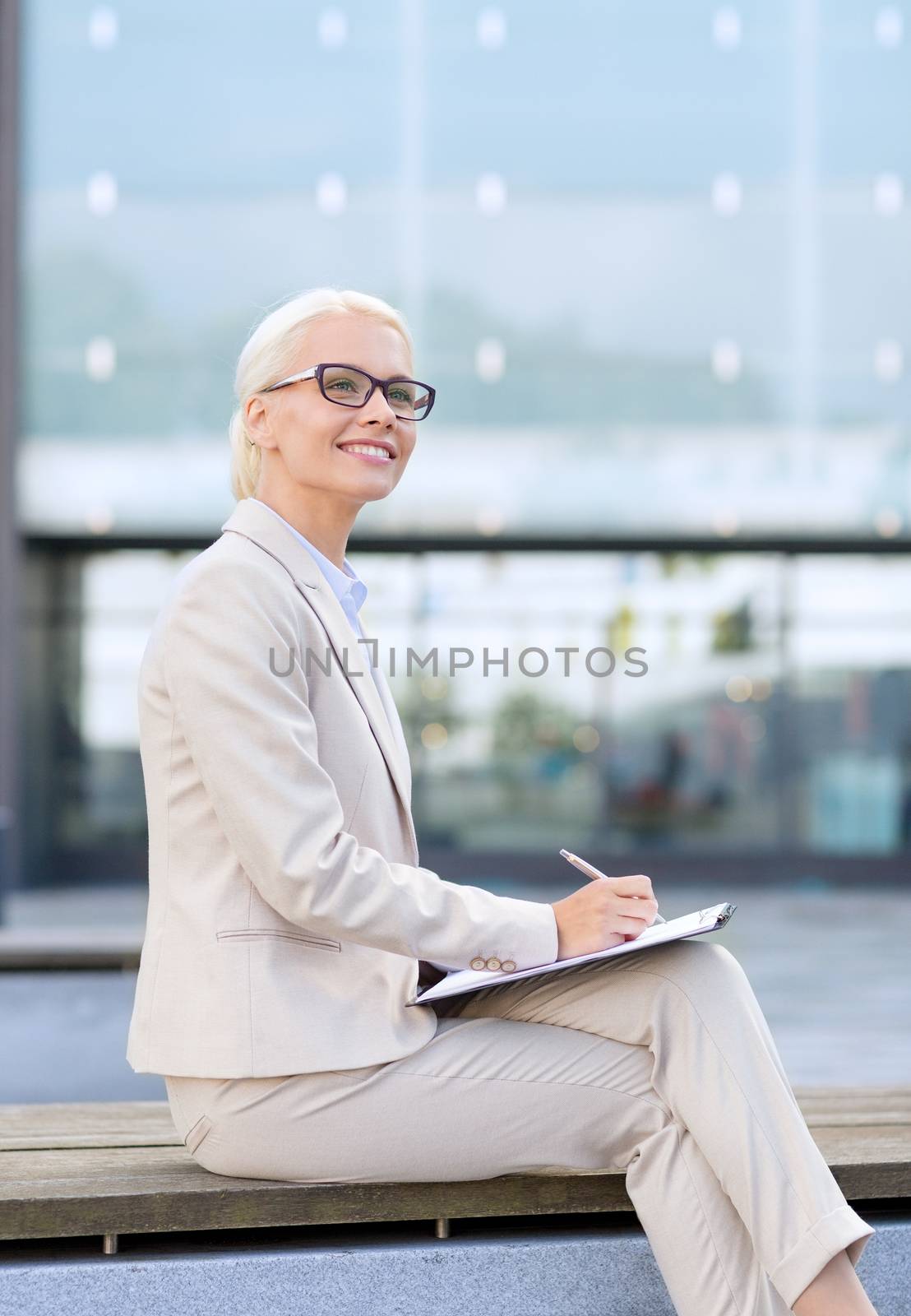 young smiling businesswoman with notepad outdoors by dolgachov