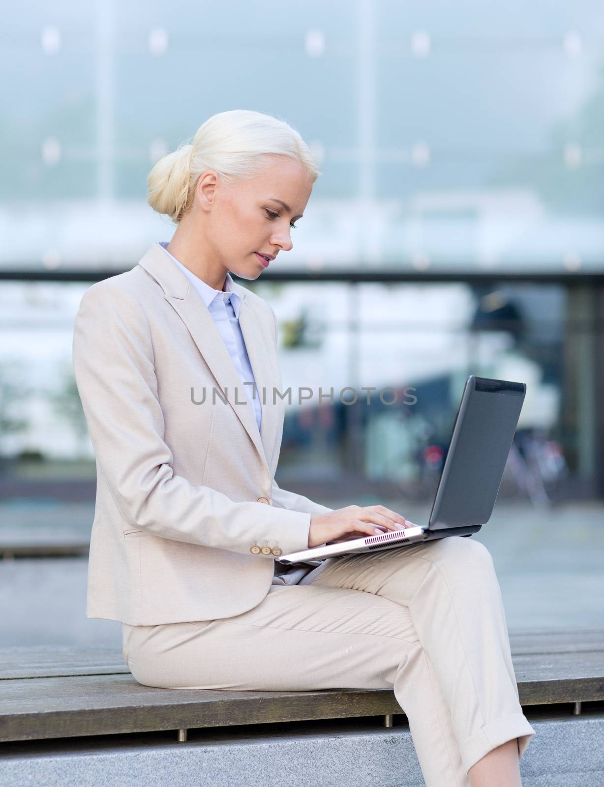 business, education, technology and people concept - businesswoman working with laptop computer on city street