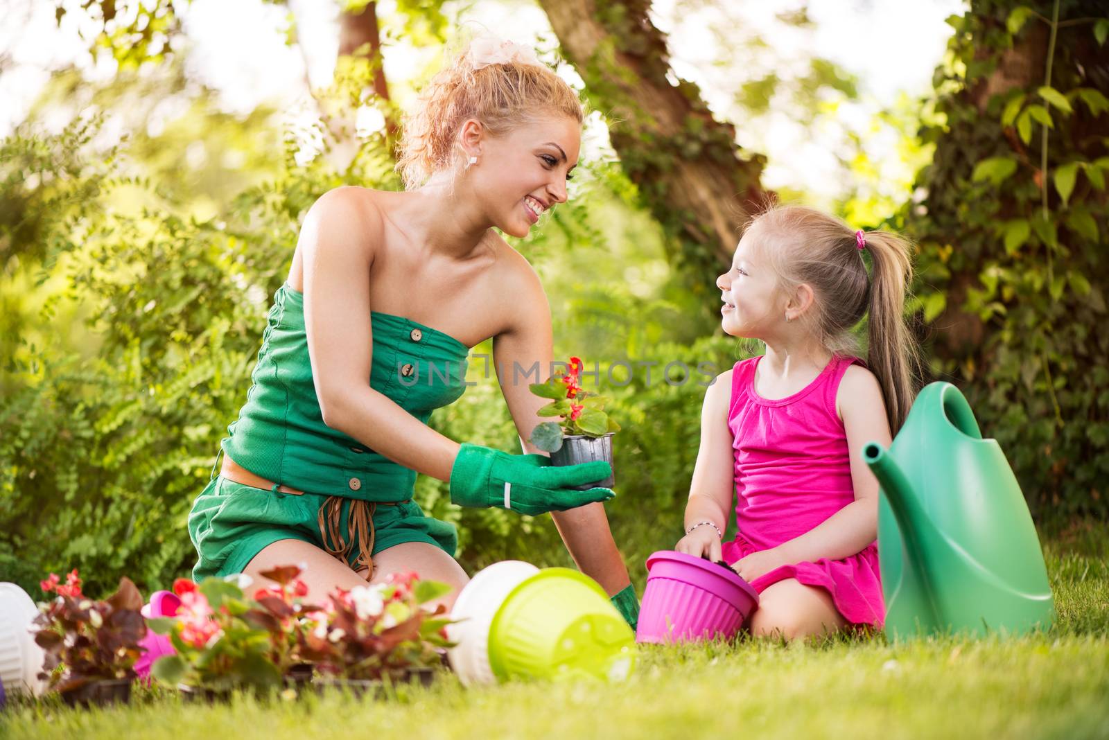 Beautiful Mother And Daughter Planting Flowers by MilanMarkovic78