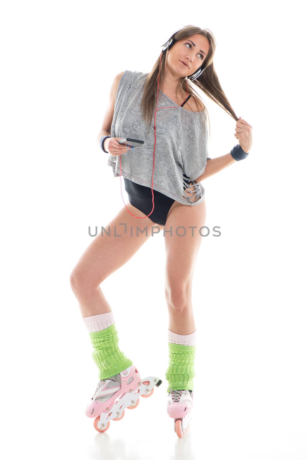 Attractive young woman in roller skates listening music. White background