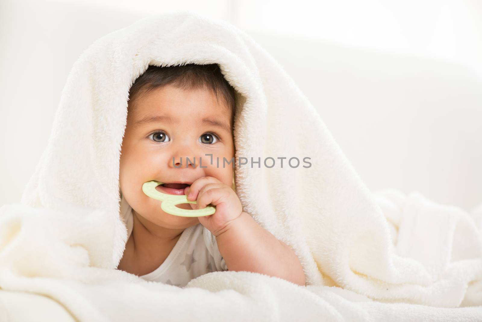 Cute baby boy lying under a blanket