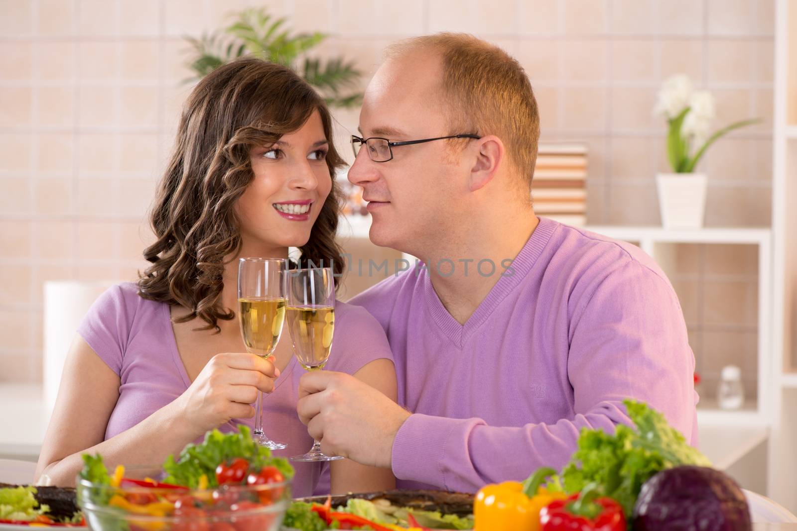 Happy Couple having dinner with champagne in a kitchen
