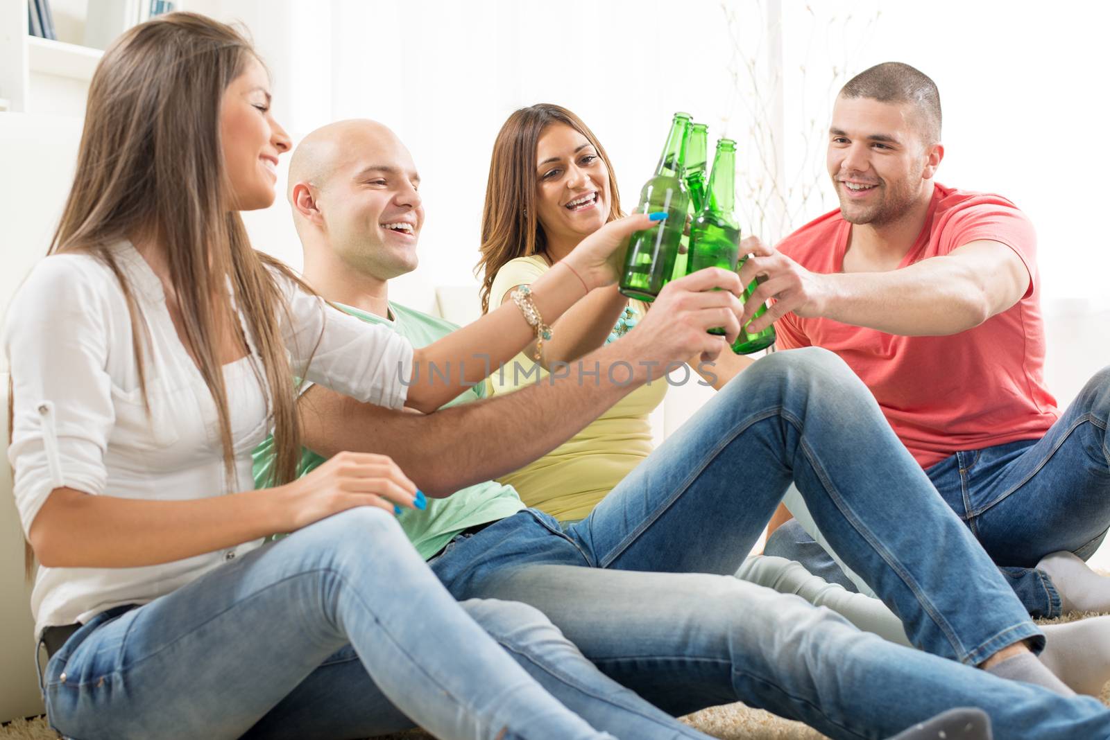 Friends enjoying with beer and cheers together at home party.